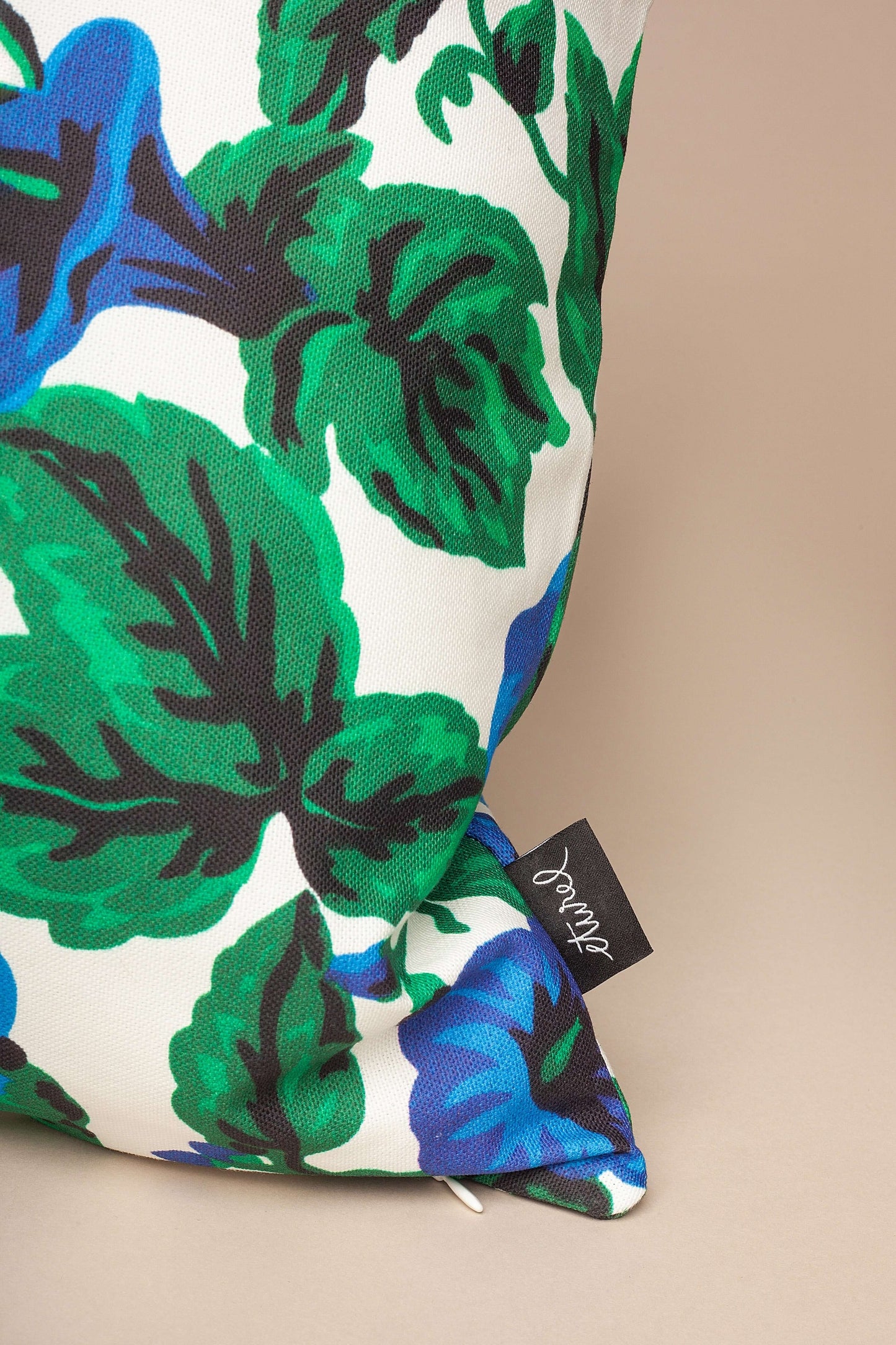 Funda de cojín de 50x50 cm en lona estilo toldo con estampado de flores azules y hojas verdes sobre fondo blanco.