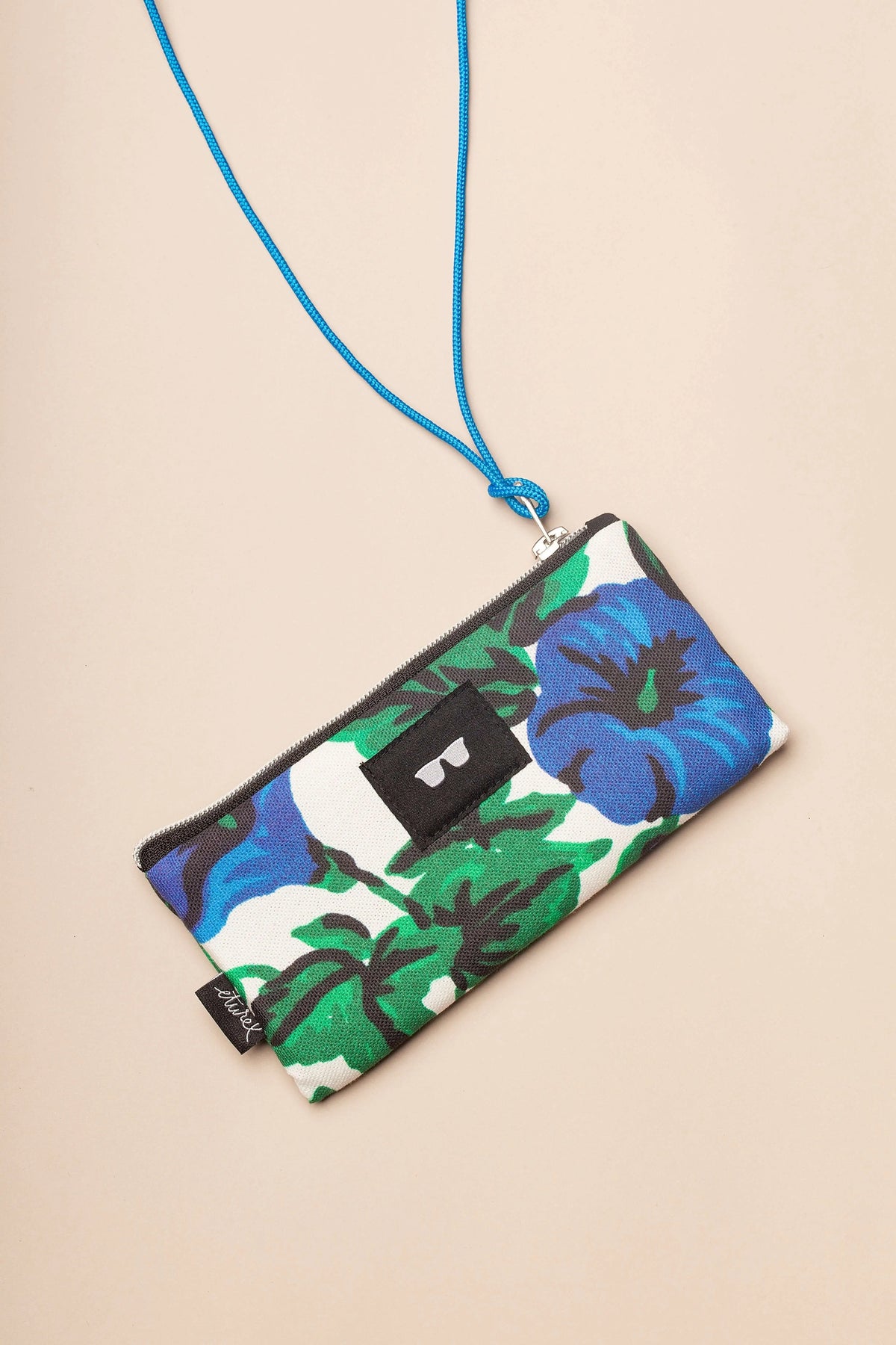 Funda de gafas de lona blanca con estampado de flores azules y hojas verdes, con cordón azul para colgar al cuello.