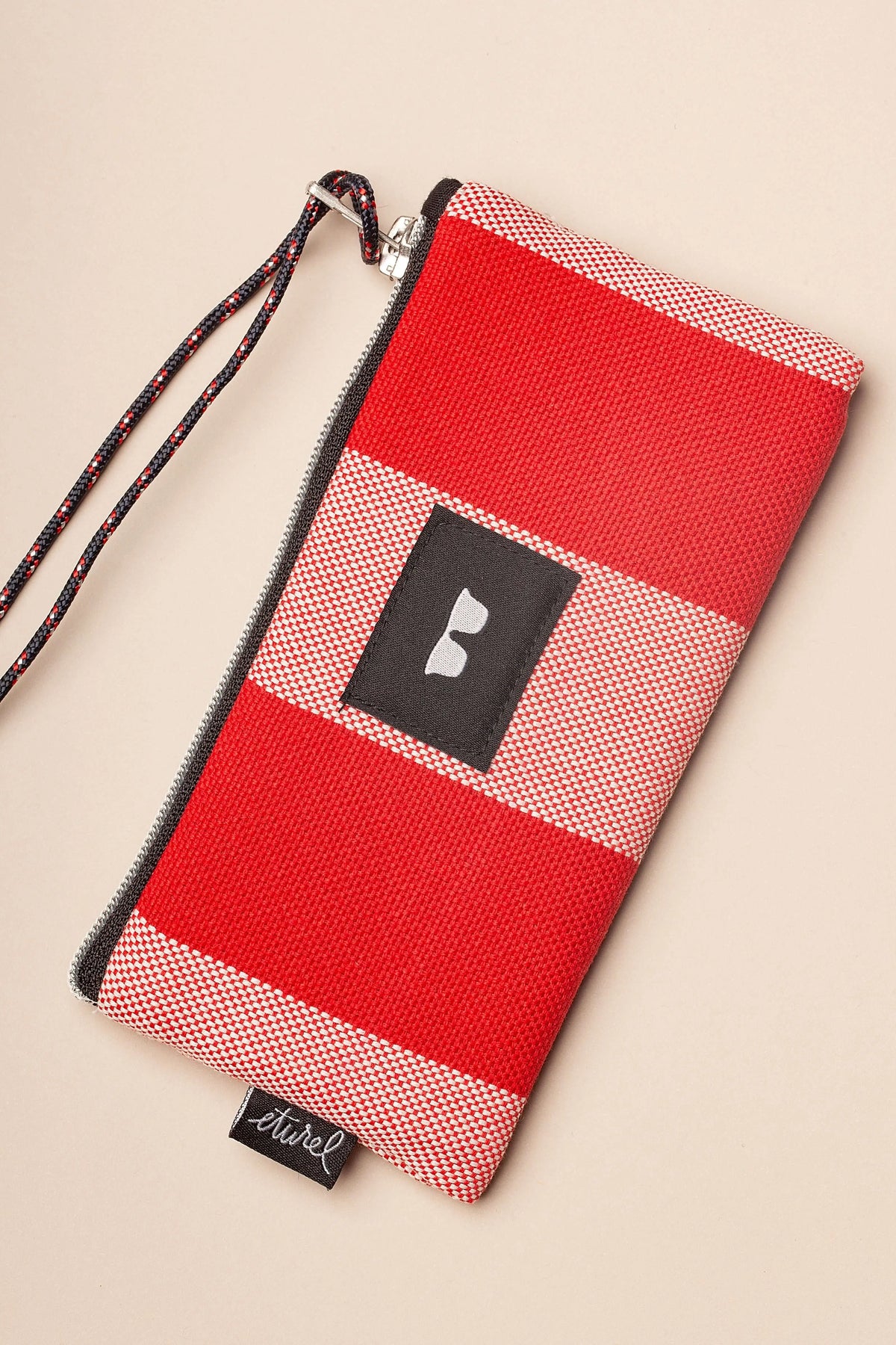 Funda para gafas de lona a rayas rojas y blancas con cremallera, parche central y cordón para colgar.