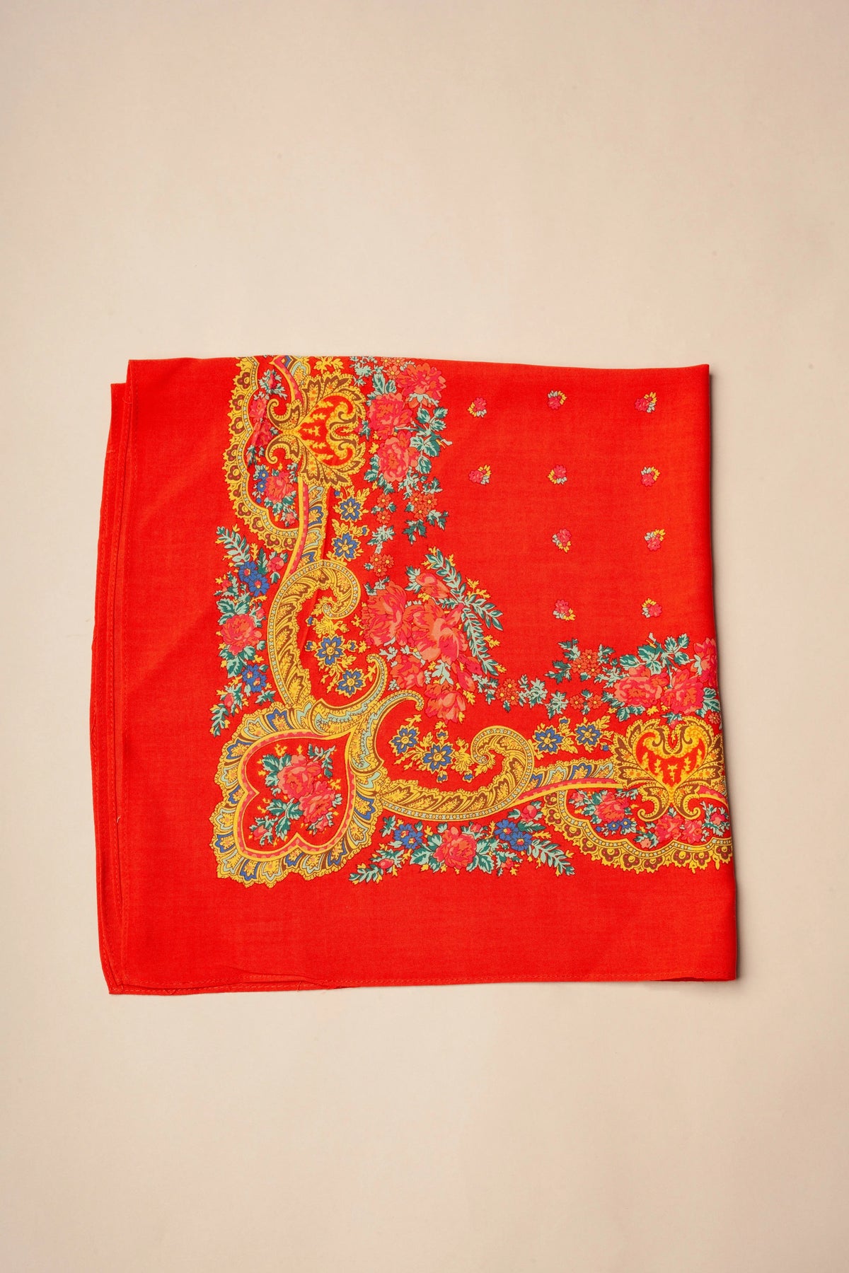 Pañuelo rojo con estampado floral, detalles de cadenas en tonos dorados y motivos tradicionales portugueses.
