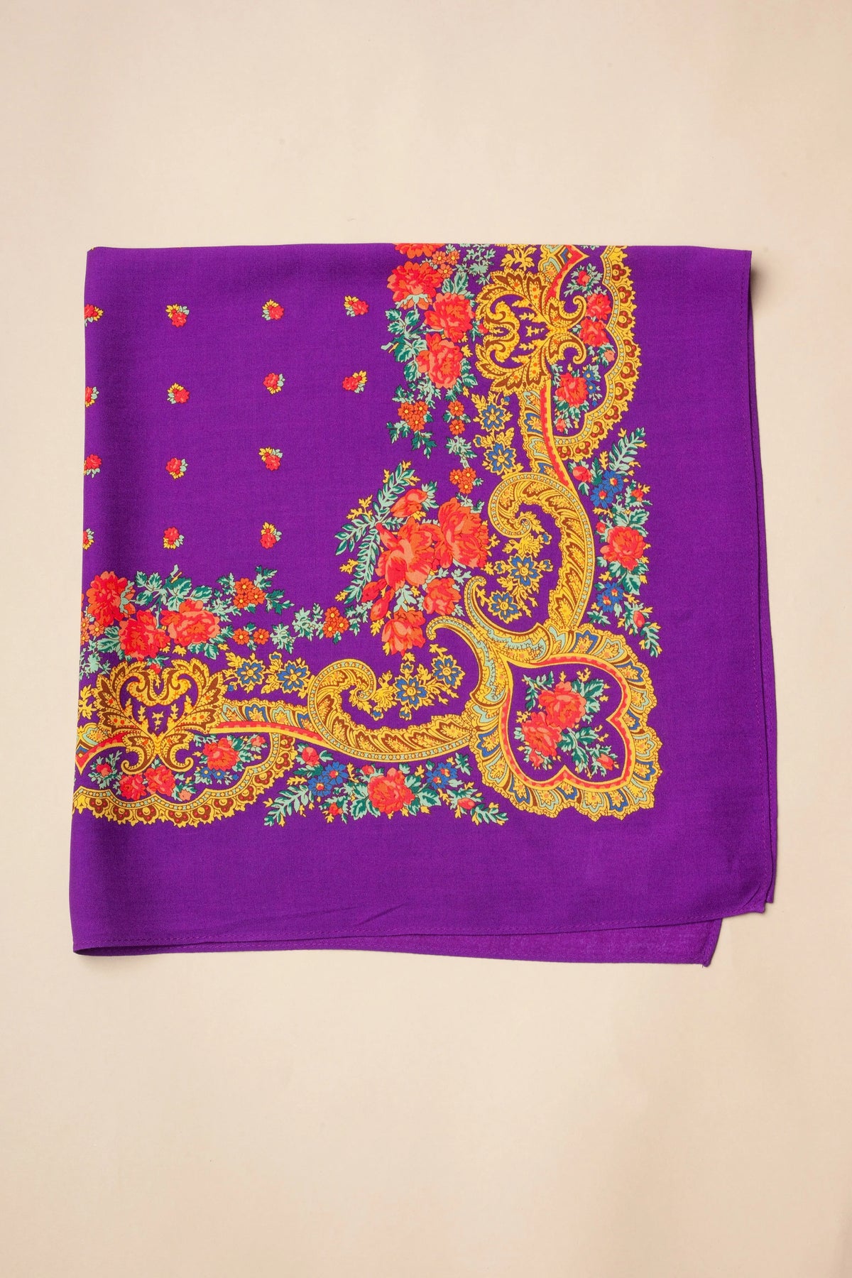 Square purple scarf with a traditional floral pattern, orange roses, and ornate gold chain motifs on a solid background.
