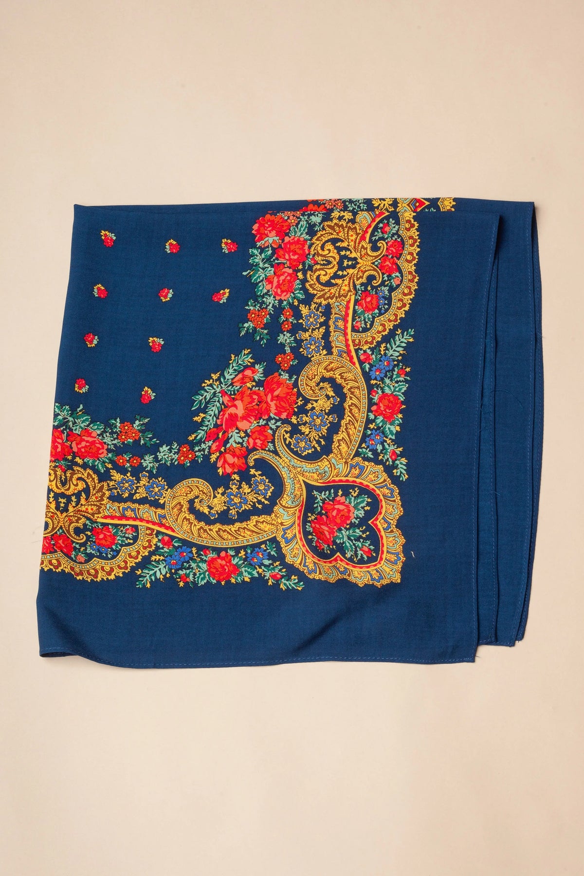 Pañuelo azul marino con estampado de flores rojas y ornamentos dorados estilo tradicional portugués.