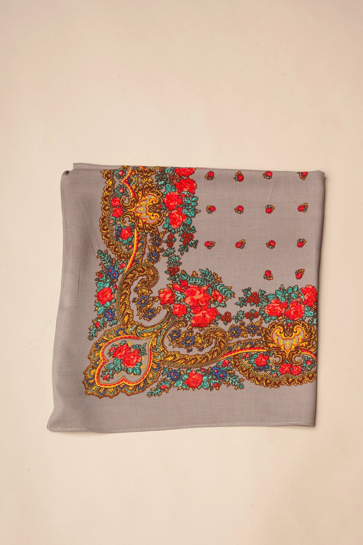 Grey square scarf with vibrant floral, paisley, and gold chain-link patterns in red, yellow, and turquoise.