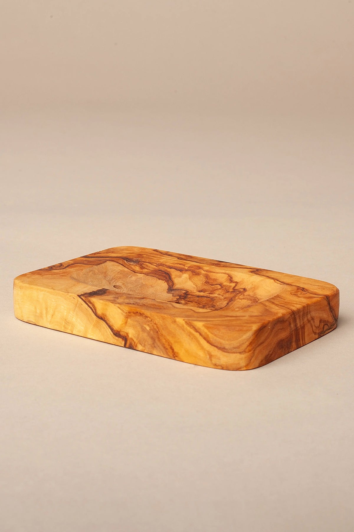 Jabonera rectangular de madera de olivo con veteado natural y acabado liso sobre fondo neutro.