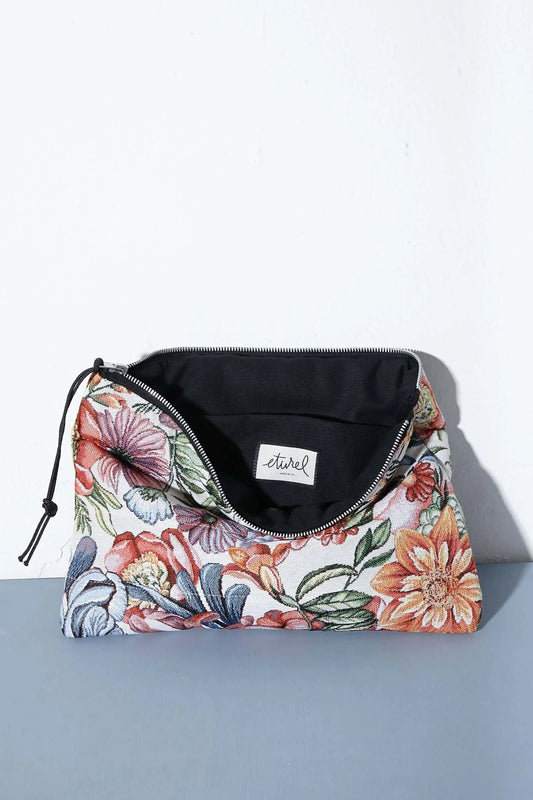 Funda para ordenador con tejido jacquard de flores estilo crisantemos en tonos rojos y naranjas sobre fondo claro.