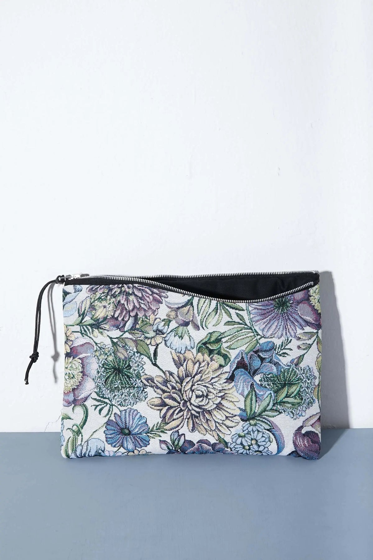 Funda rectangular de tejido jacquard con estampado de flores y crisantemos en tonos azules, morados y verdes con cremallera.
