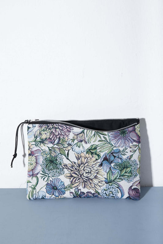 Funda rectangular de tejido jacquard con estampado de flores y crisantemos en tonos azules, morados y verdes con cremallera.
