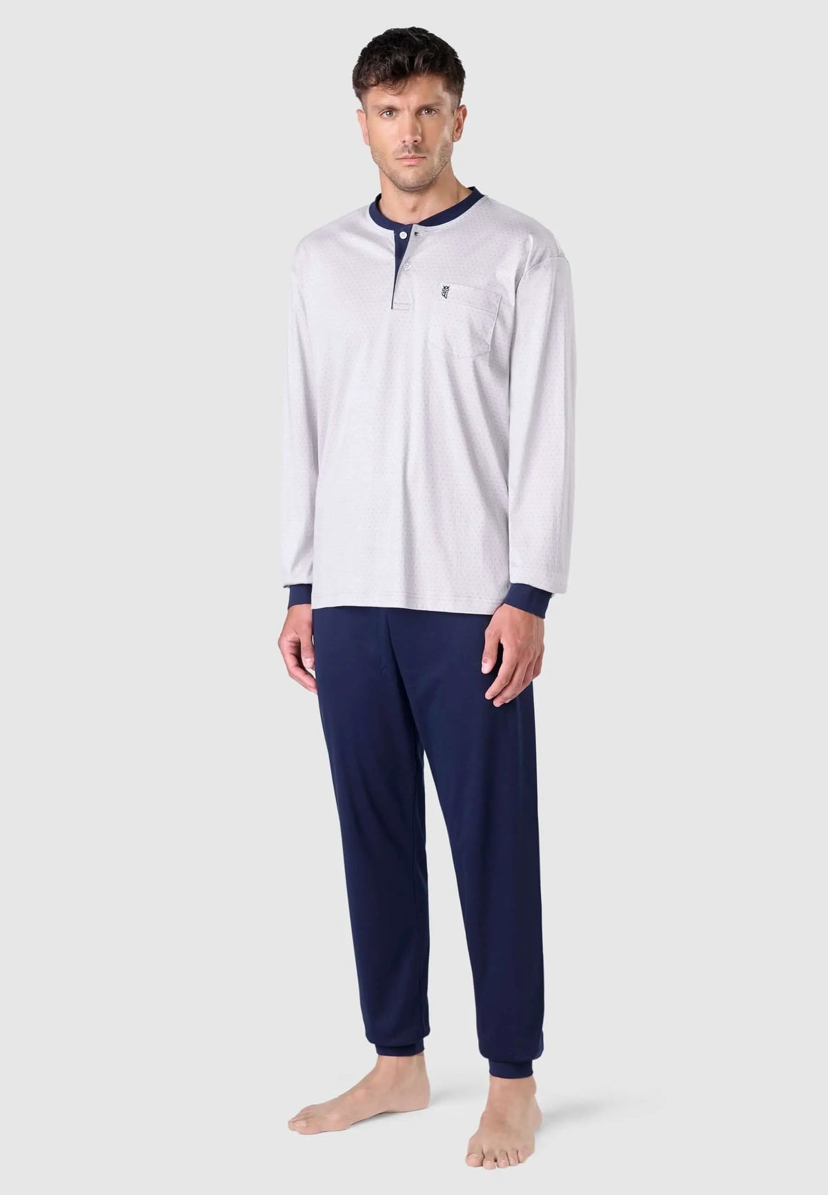 Pijama hombre gris estampado con tapeta de botones, cuello y puños azul marino, modelo de manga larga y pantalón largo.