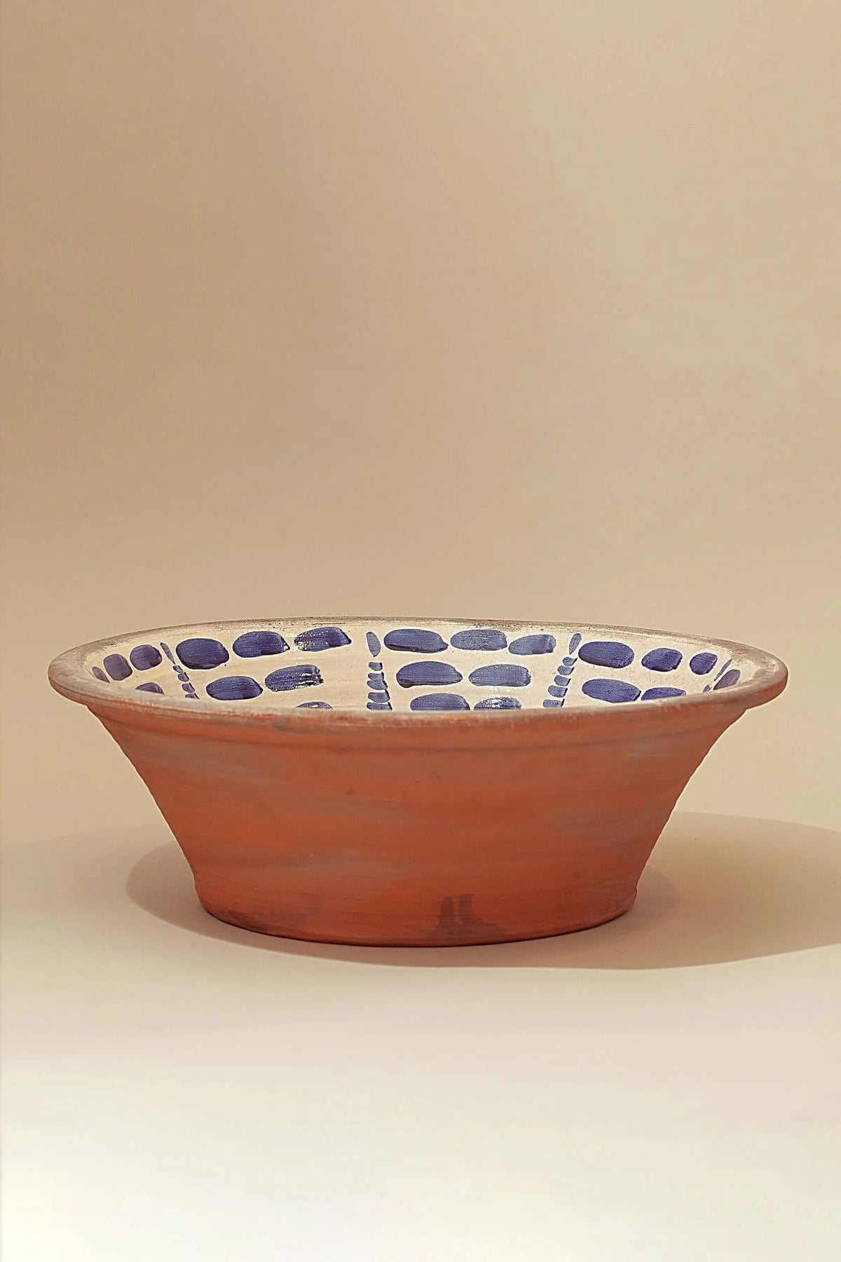 Lebrillo artesanal de cerámica terracota con interior blanco y cenefa de trazos azules estilo granadino.