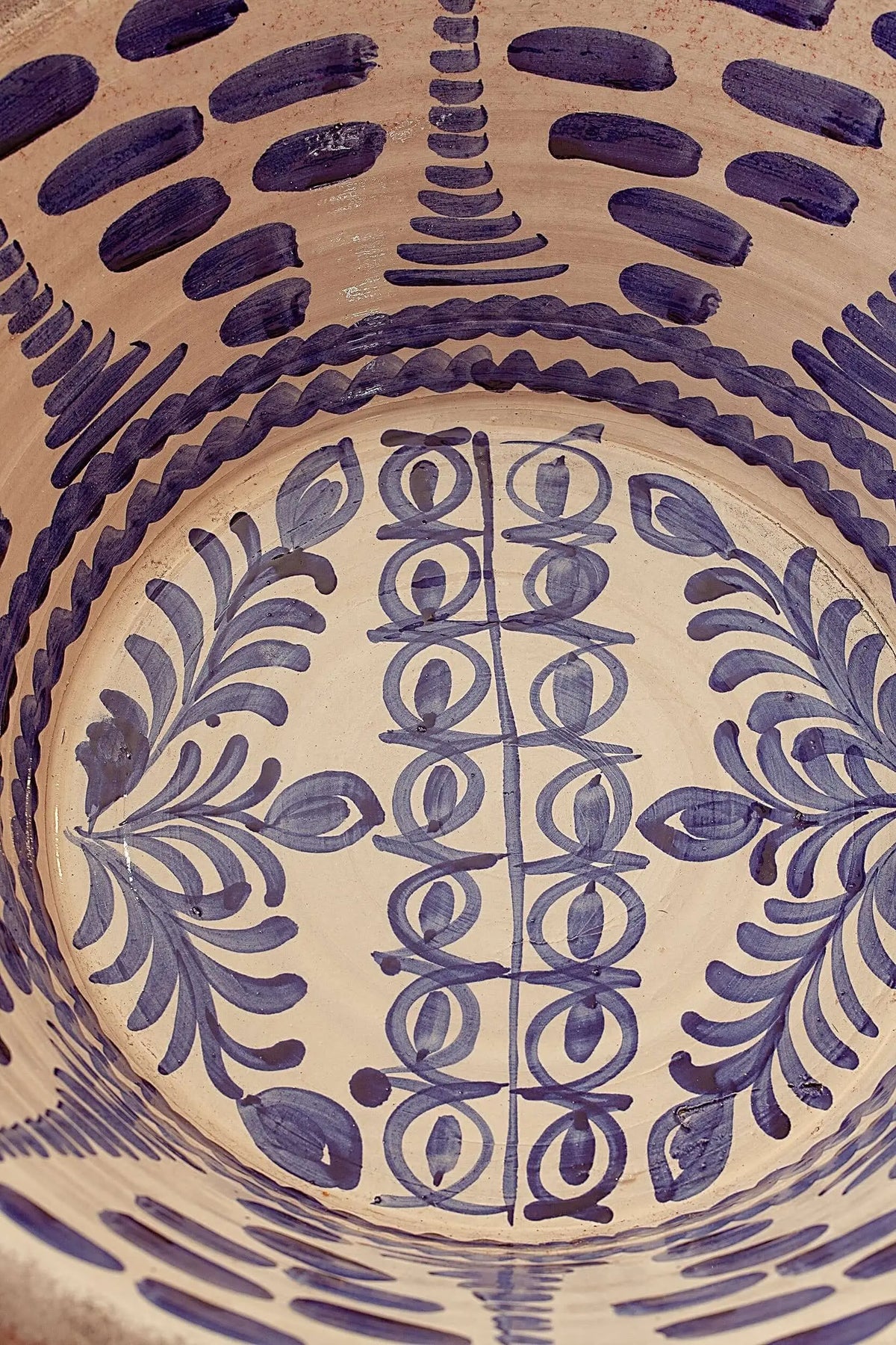 Lebrillo de cerámica artesanal con fondo crema y pintura azul tradicional en motivos vegetales y geométricos.