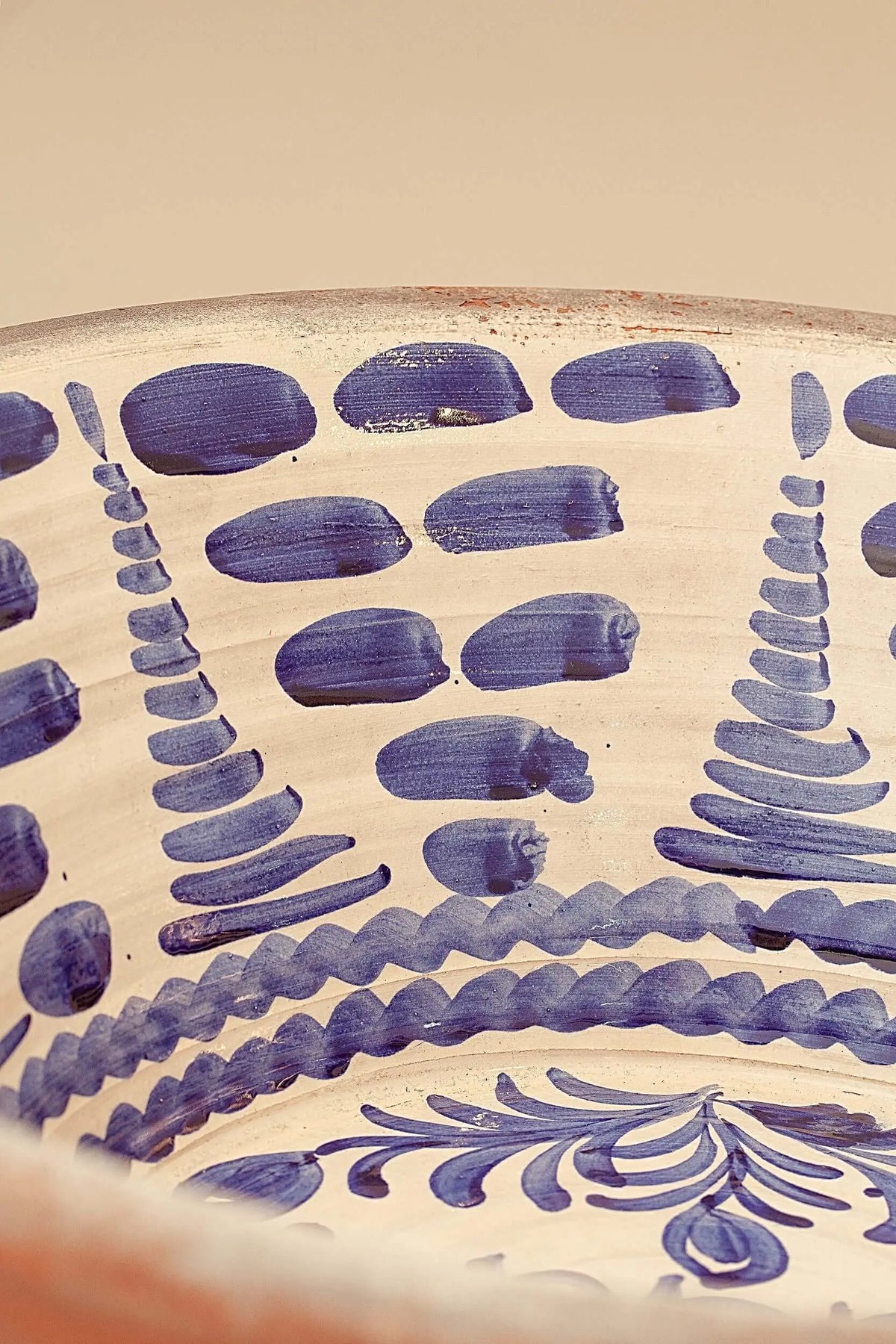 Lebrillo de cerámica artesanal con motivos pintados en azul sobre fondo crema de estilo tradicional andaluz.