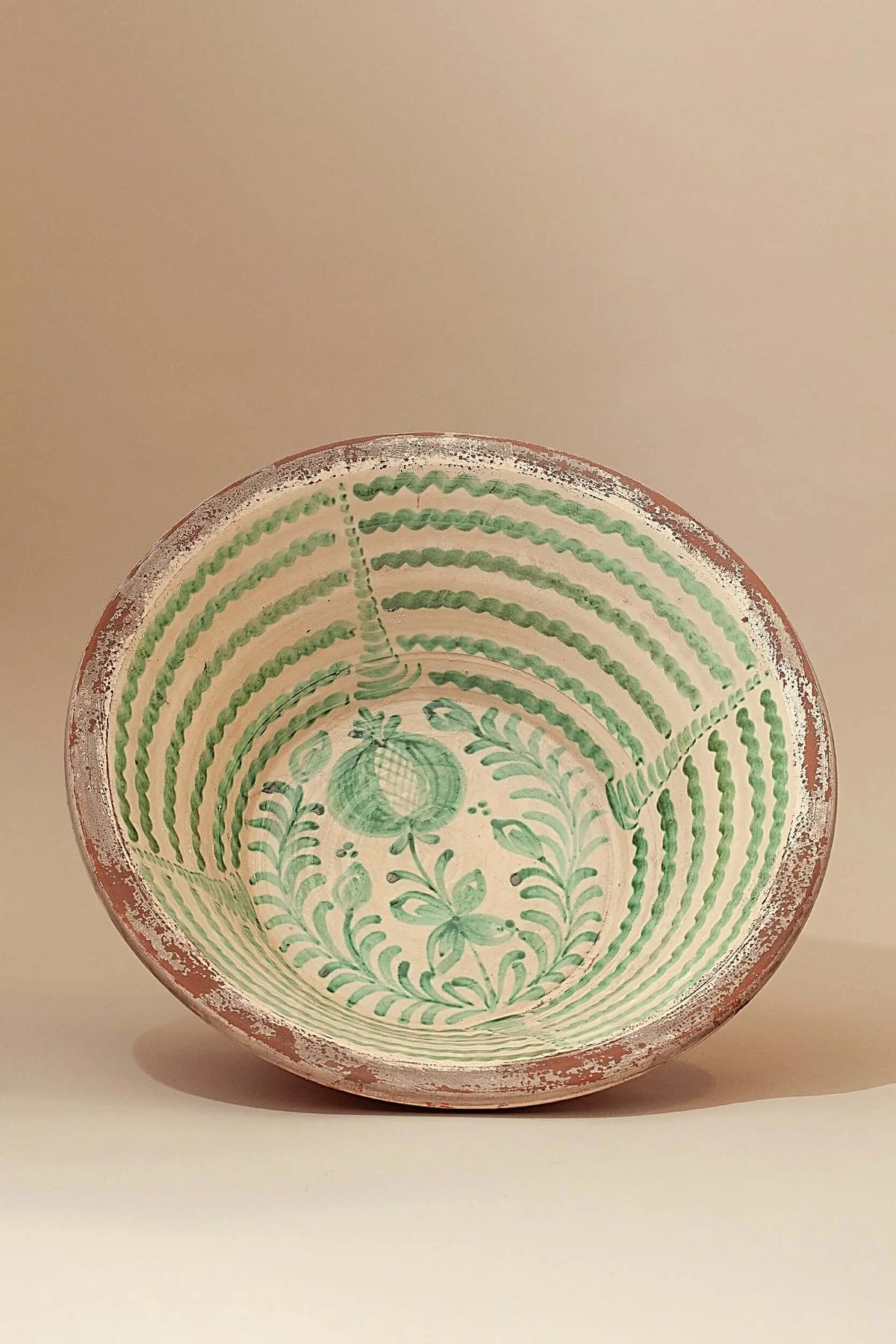 Lebrillo de cerámica artesanal con fondo crema y pintura verde de estilo granadino con motivos florales y geométricos.