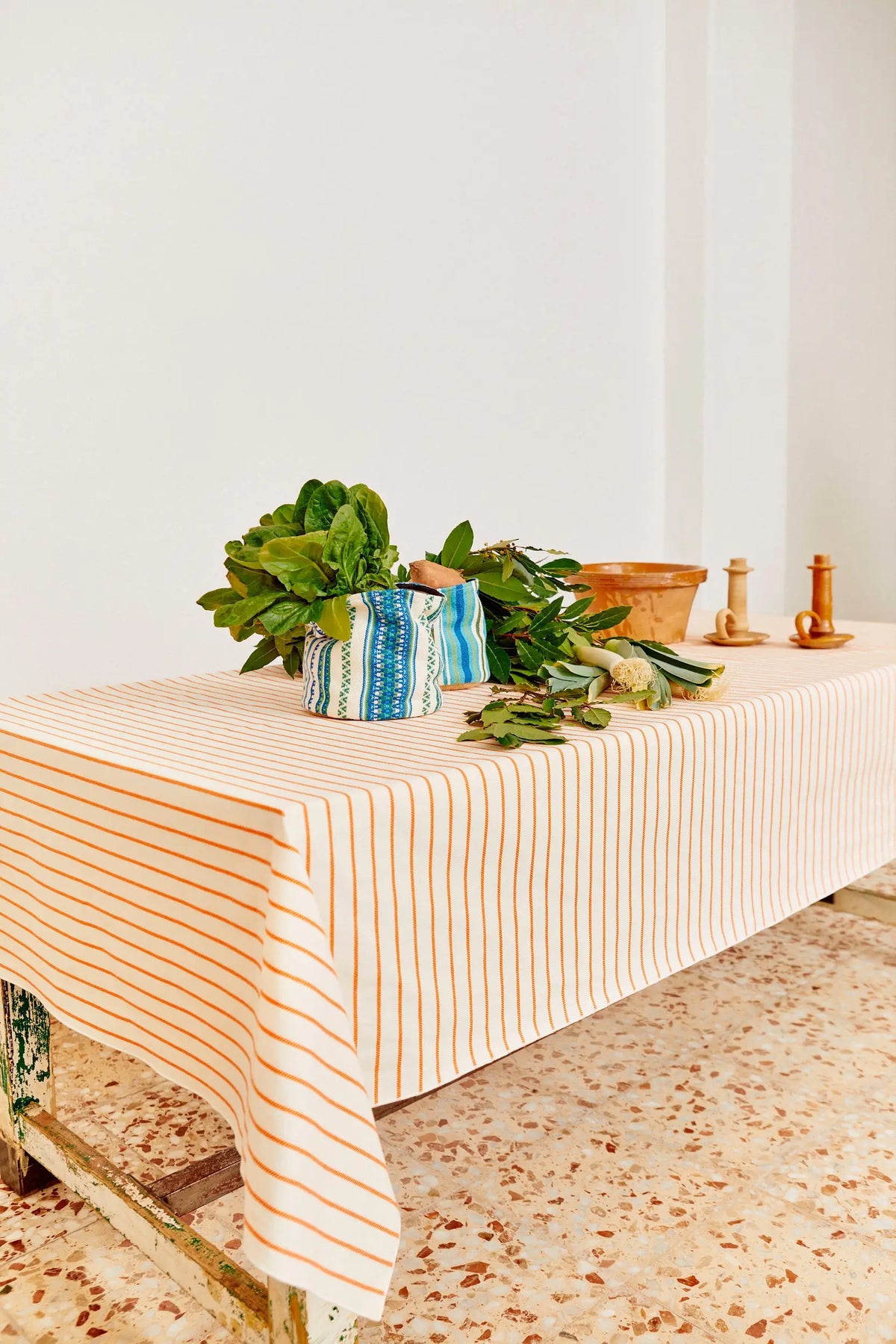Mantel de algodón blanco con rayas verticales finas en color naranja, estilo rústico y natural.