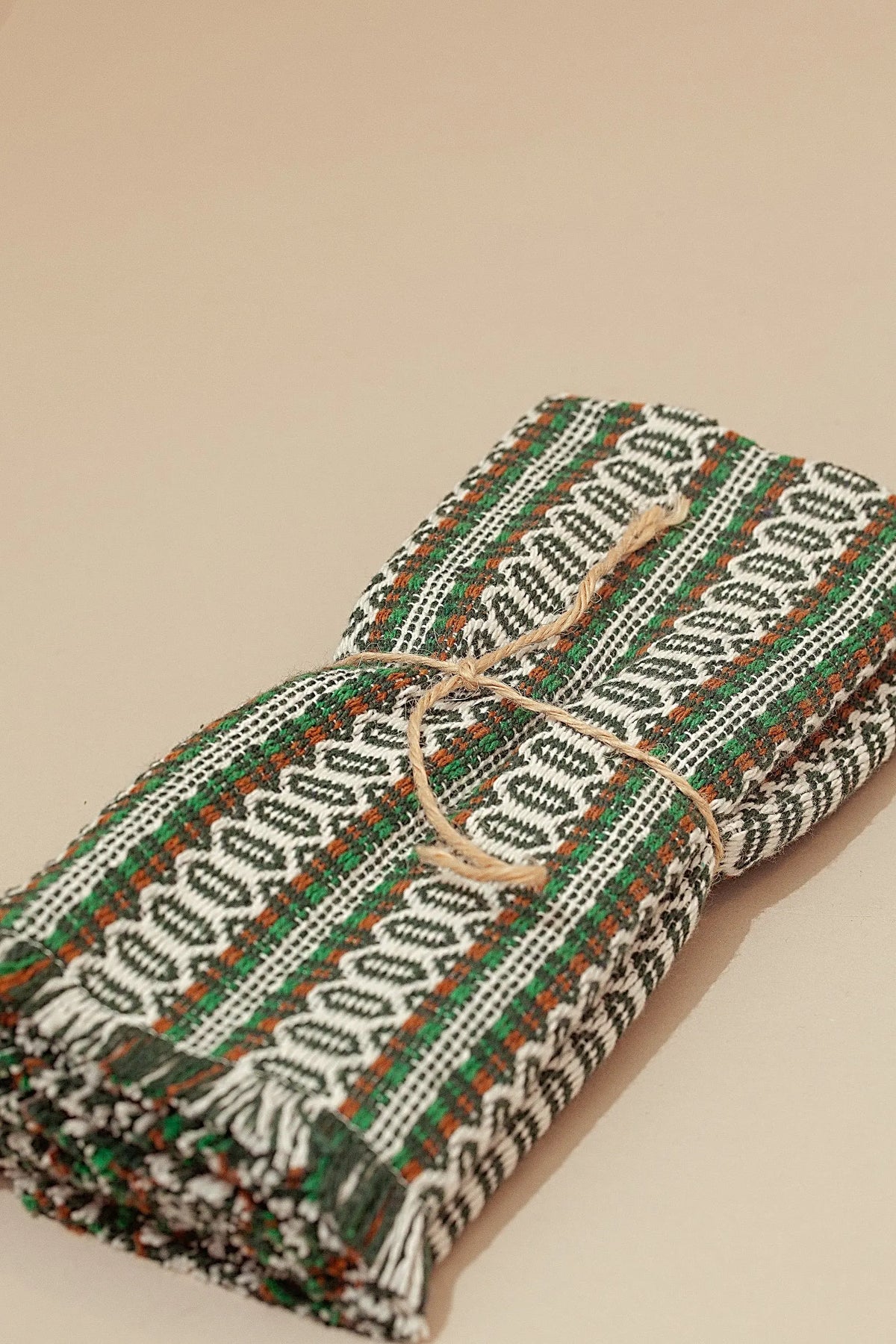 Pack de 2 manteles individuales de tela tejida con estampado ojo de perdiz en tonos verde, marrón y blanco.