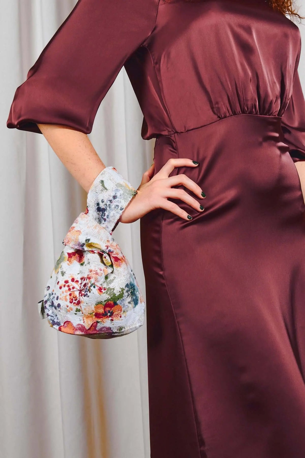 Bolso hatillo mini de tela jacquard con estampado floral de amapolas en tonos vivos sobre fondo claro.