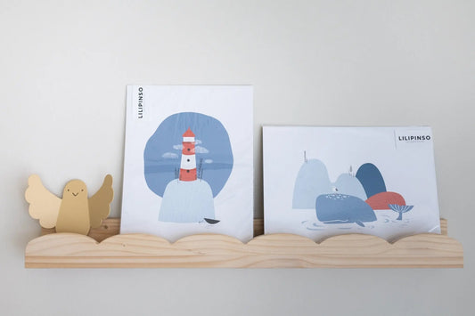 Imágenes de arte en colores azul y rojo con un faro y montañas, en marco de madera claro. Ideal para decoración infantil.