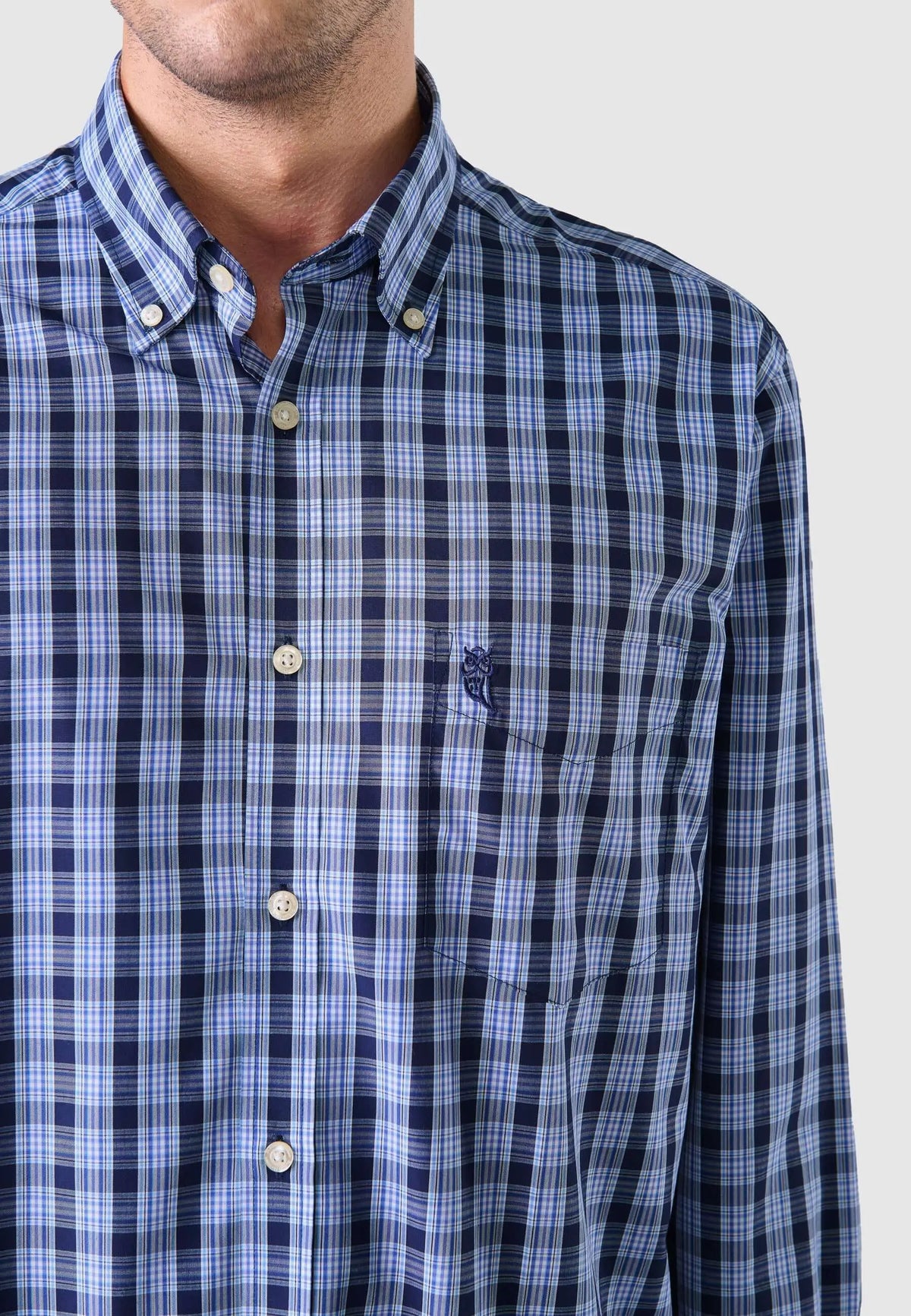 Camisa de hombre manga larga en popelín azul de cuadros, estilo casual, con bolsillo frontal y cuello abotonado.