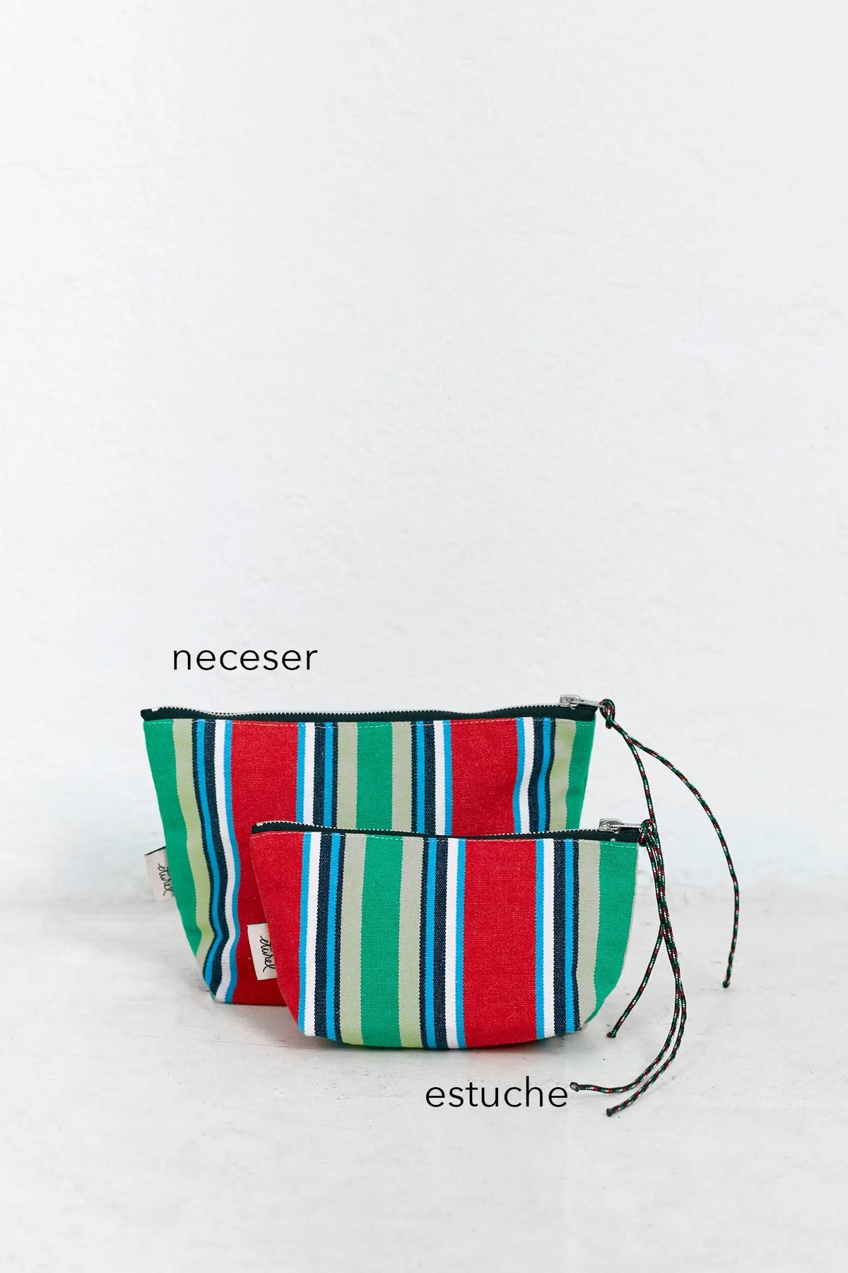 Neceser y estuche de lona con rayas verticales en rojo, verde, azul y blanco, con cierre de cremallera y cordón.