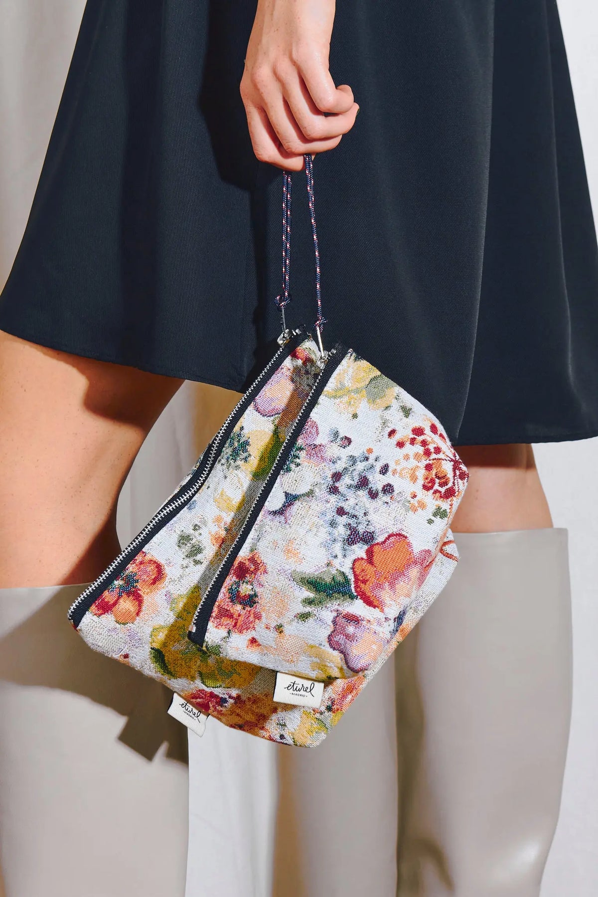 Neceser de tela jacquard con estampado floral de amapolas multicolor, cierre de cremallera y asa de cordón.