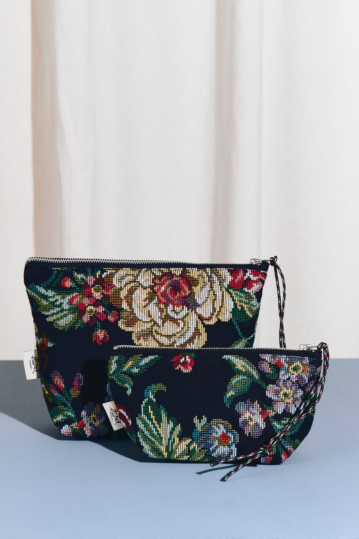 Set de dos neceseres de tejido jacquard negro con estampado floral de peonías y cremallera, estilo elegante y compacto.
