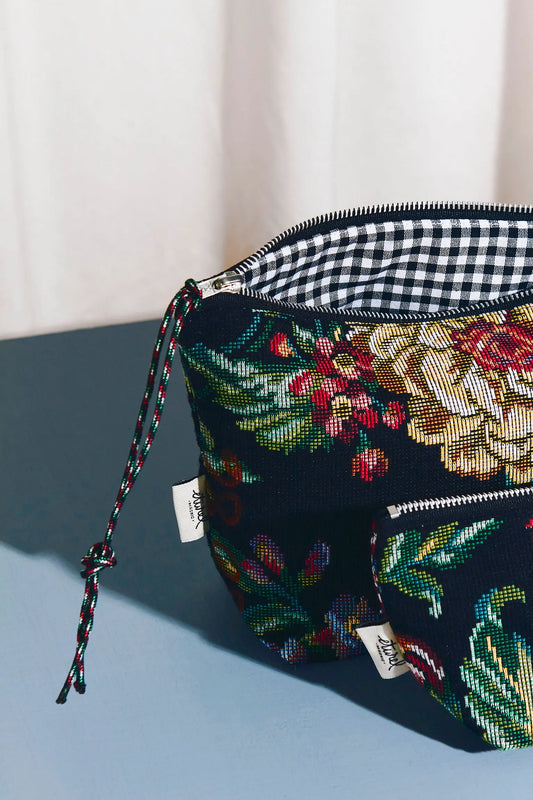 Neceser de tejido jacquard con estampado de peonías y forro de cuadros vichy blanco y negro, cierre de cremallera.