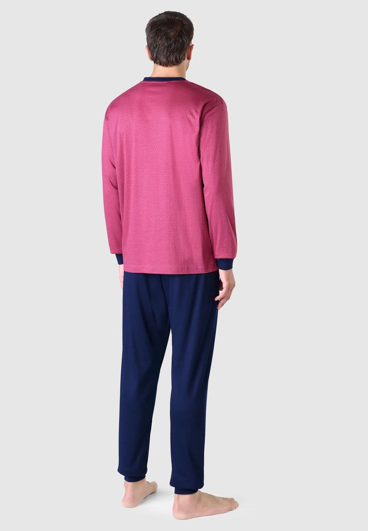 Pijama de hombre rojo estampado con detalles en azul marino, manga larga y pantalón largo, visto de espaldas.