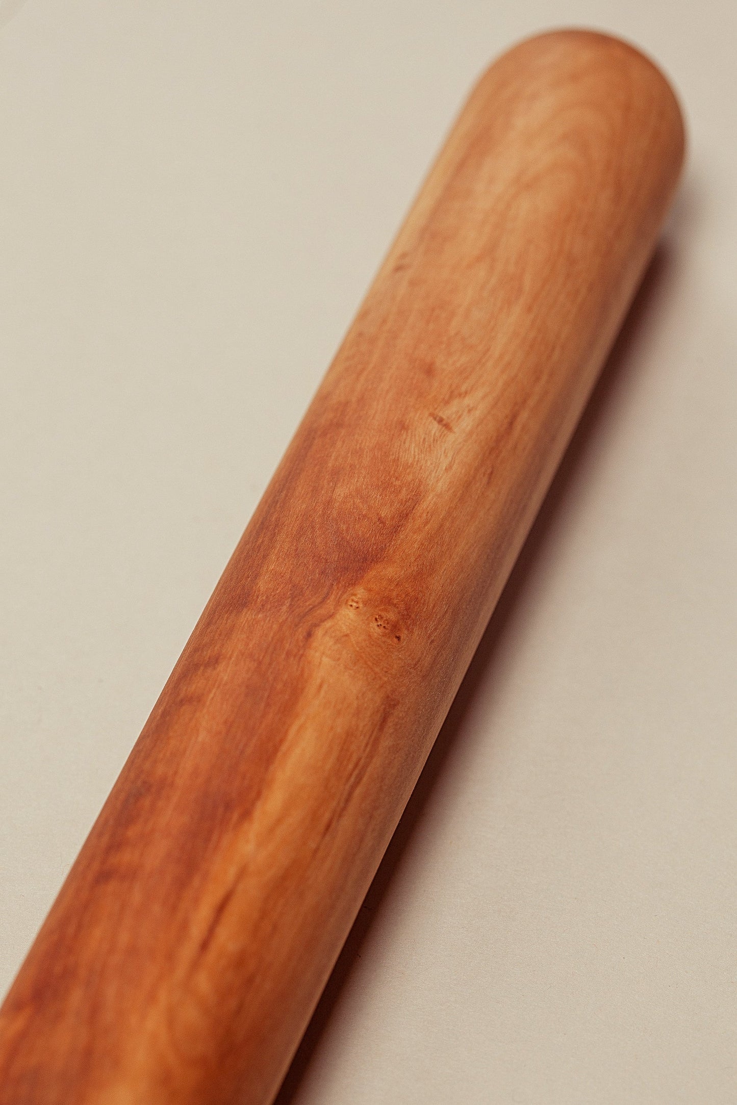 Rodillo de amasar de madera de olivo con veteado natural y tono cálido, diseño artesanal liso y minimalista.
