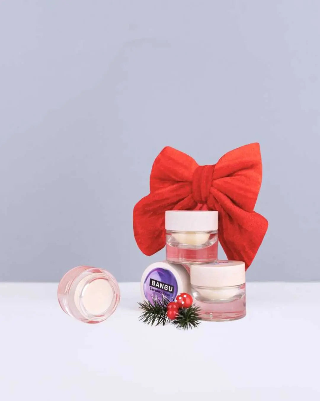 Pack de perfumes sólidos Banbu en tarros de cristal con tapa de madera, decorados con un lazo rojo y detalle navideño.