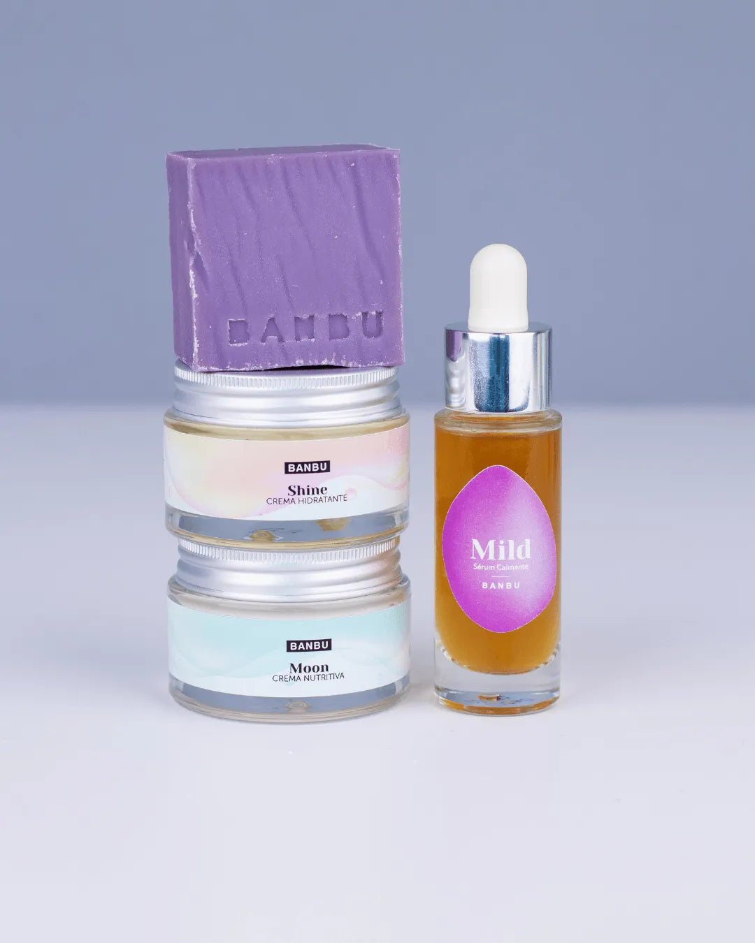Pack facial Banbu: pastilla de jabón morada, dos cremas en tarros de cristal y un sérum ámbar con cuentagotas.