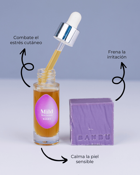 Sérum Banbu con gotero y pastilla de jabón lila sobre fondo azul. Etiquetas indican beneficios para piel sensible.