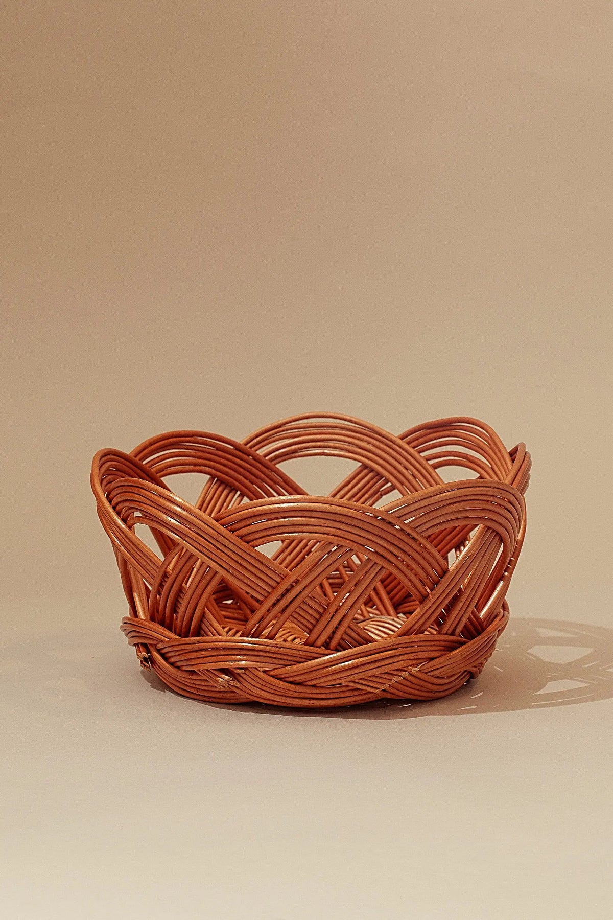 Round natural wicker bread basket with a decorative open-weave scalloped rim in a warm honey-brown finish.