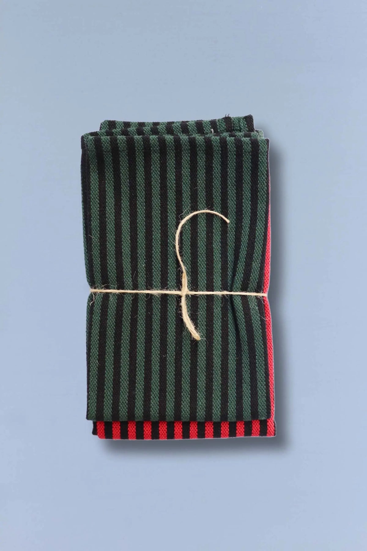 Set de dos paños de cocina de loneta con diseño de rayas verticales en colores verde y rojo, atados con cuerda natural.