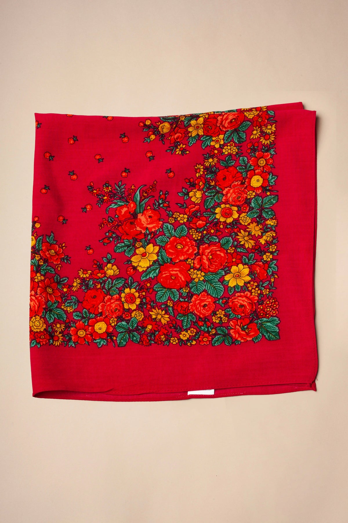 Square red Portuguese scarf featuring vibrant floral patterns in pink, yellow, and green, with a traditional print.