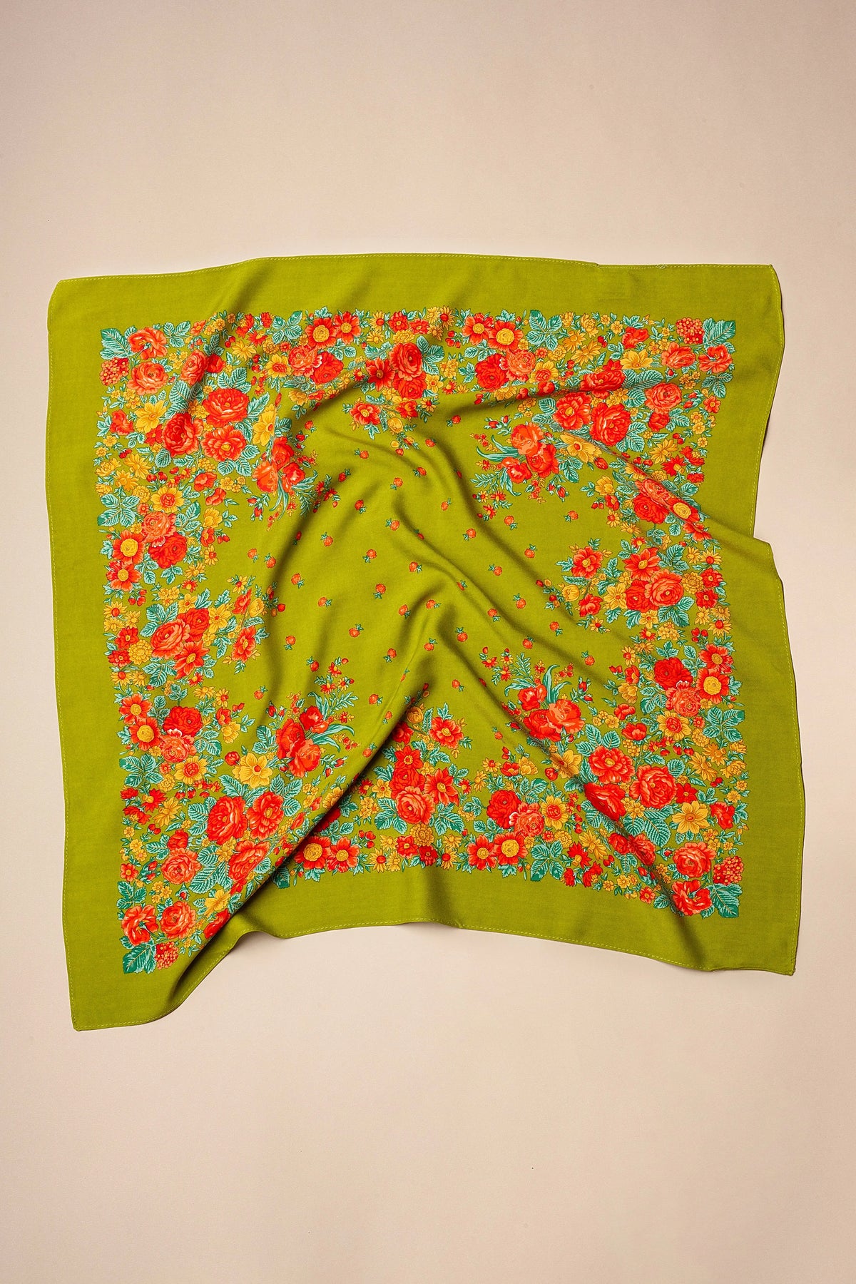 Pañuelo cuadrado color verde oliva con estampado tradicional de flores rojas, naranjas y amarillas.