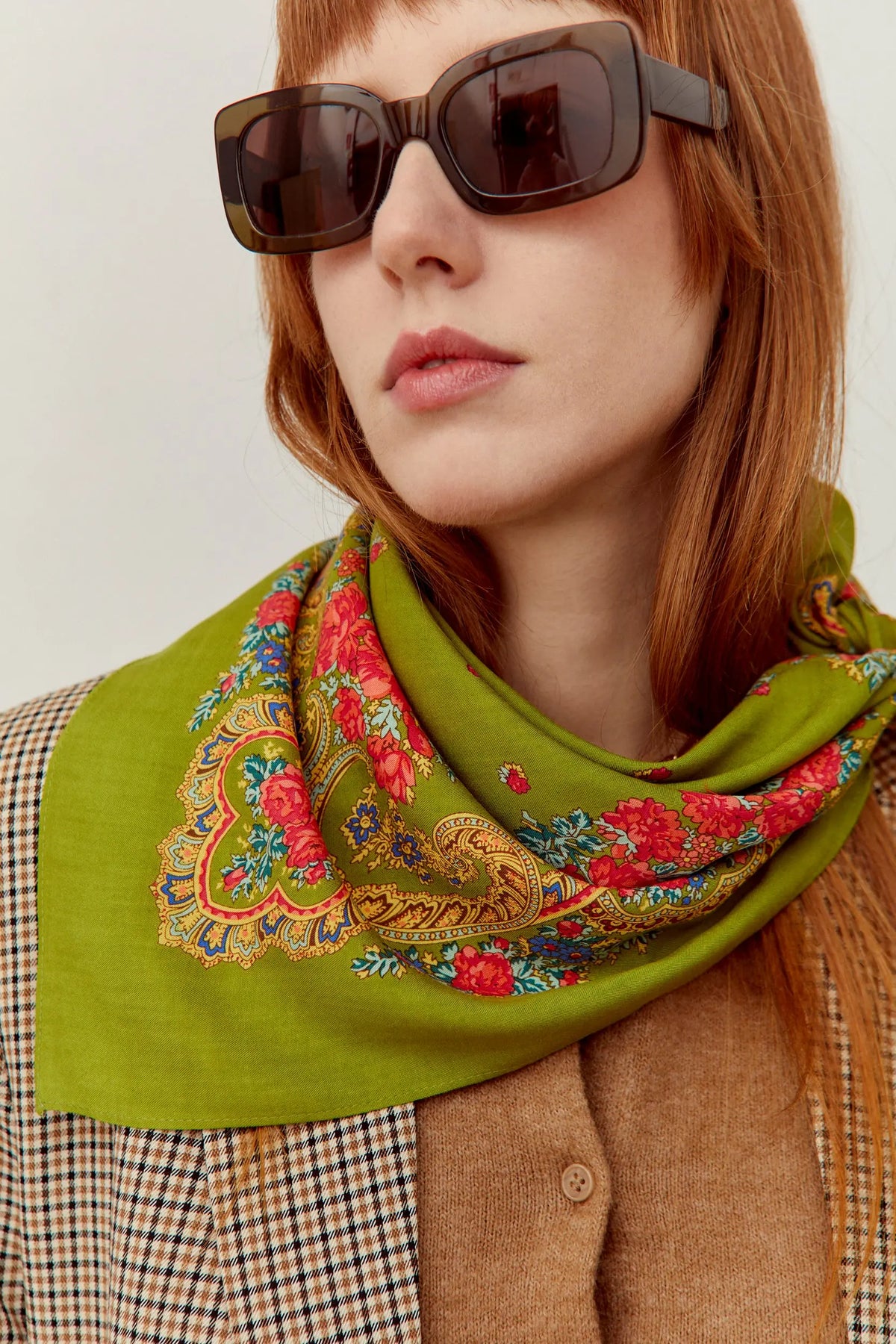 Pañuelo verde oliva con estampado floral y geométrico multicolor, estilo tradicional portugués, sobre una mujer.