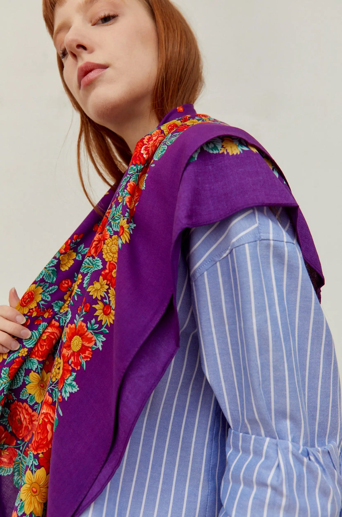 Pañuelo de tela morado con estampado de flores coloridas estilo tradicional portugués sobre los hombros de una mujer.
