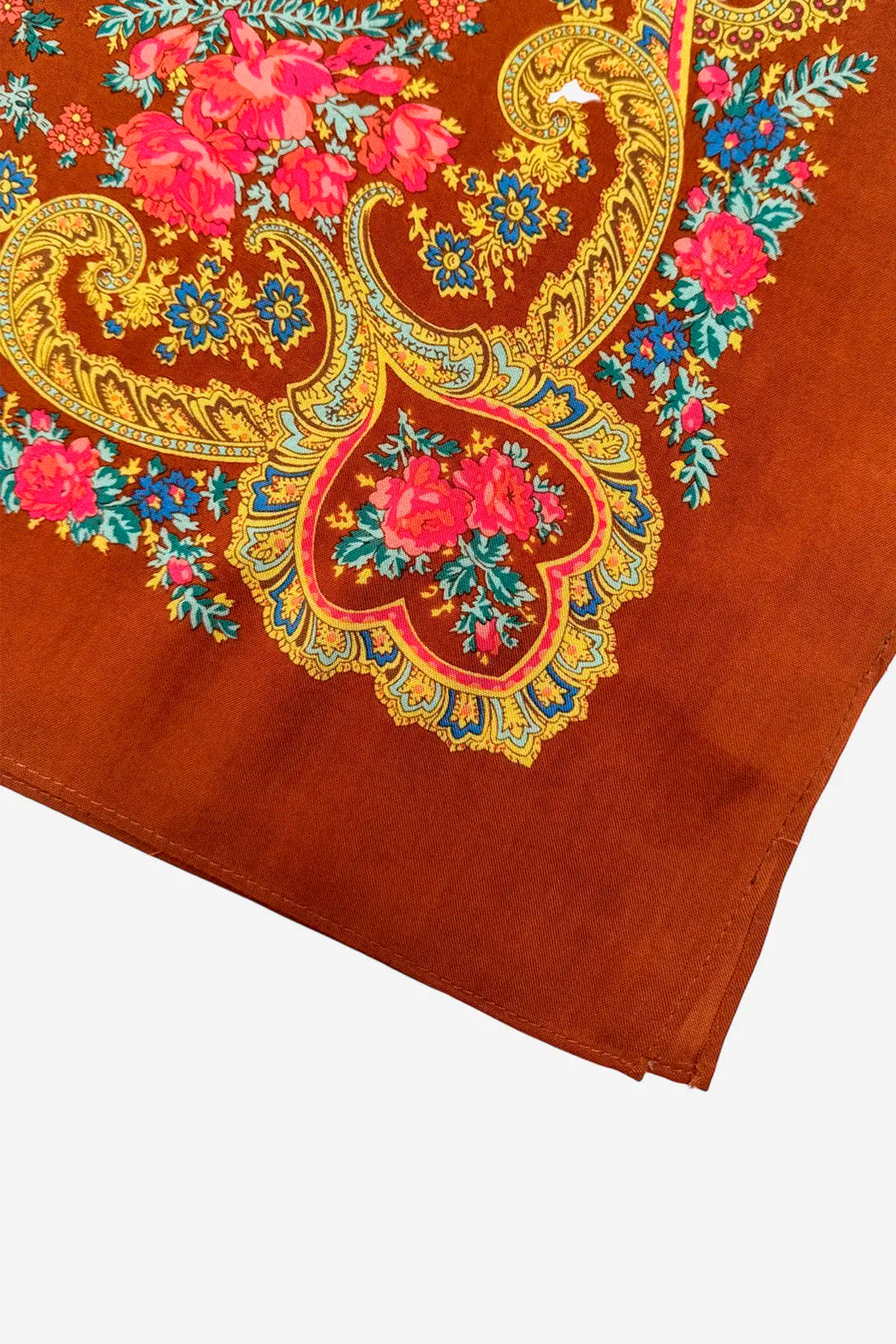 Rust-orange shawl featuring vibrant floral patterns, paisley-like golden scrolls, and bright pink and blue accents.