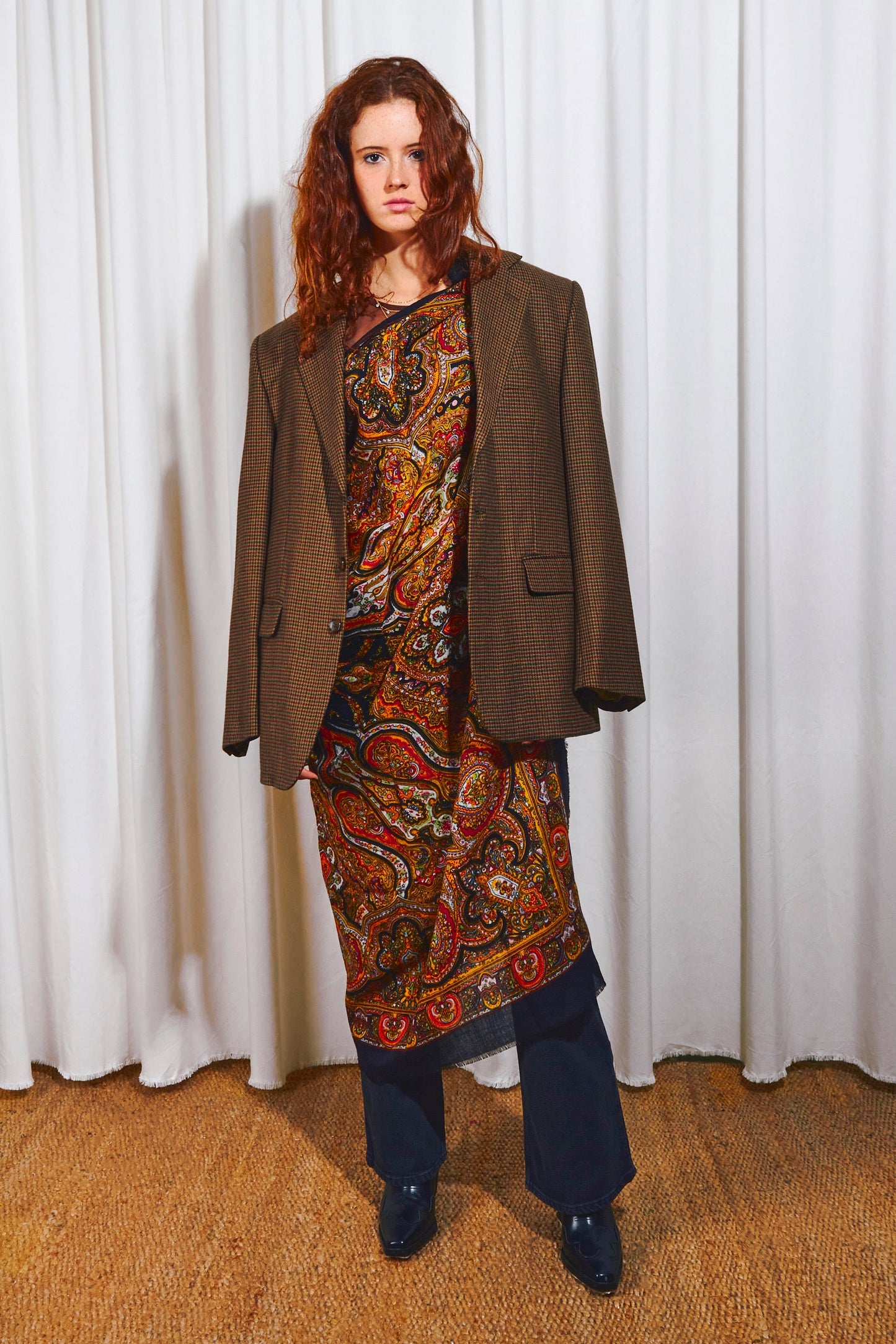 Pañuelo de lana negro con estampado paisley multicolor, estilo elegante, usado sobre una americana y pantalones oscuros.