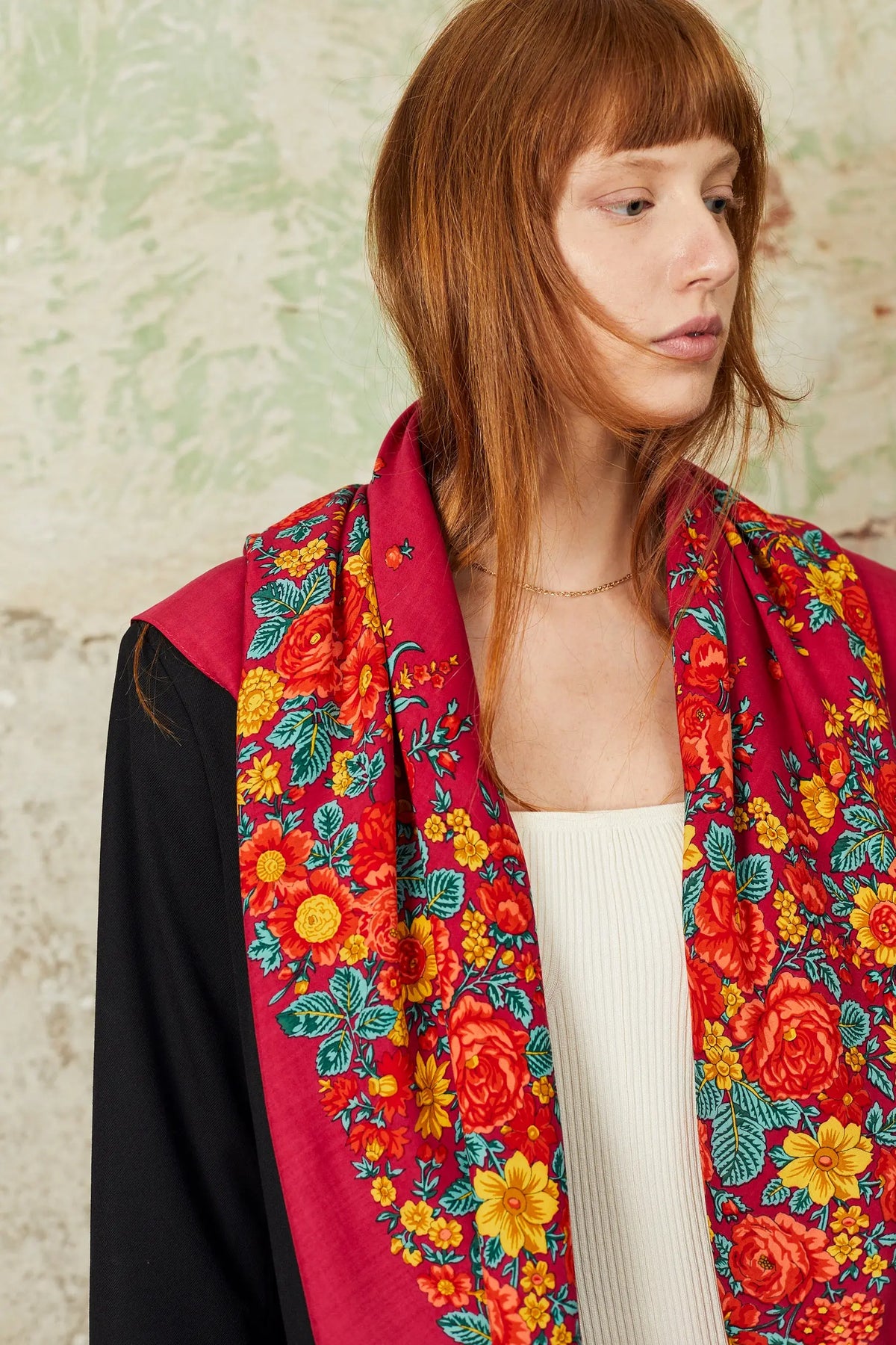 Pañuelo de estilo portugués en color rosa con estampado de flores vibrantes en tonos rojos, amarillos y hojas verdes.