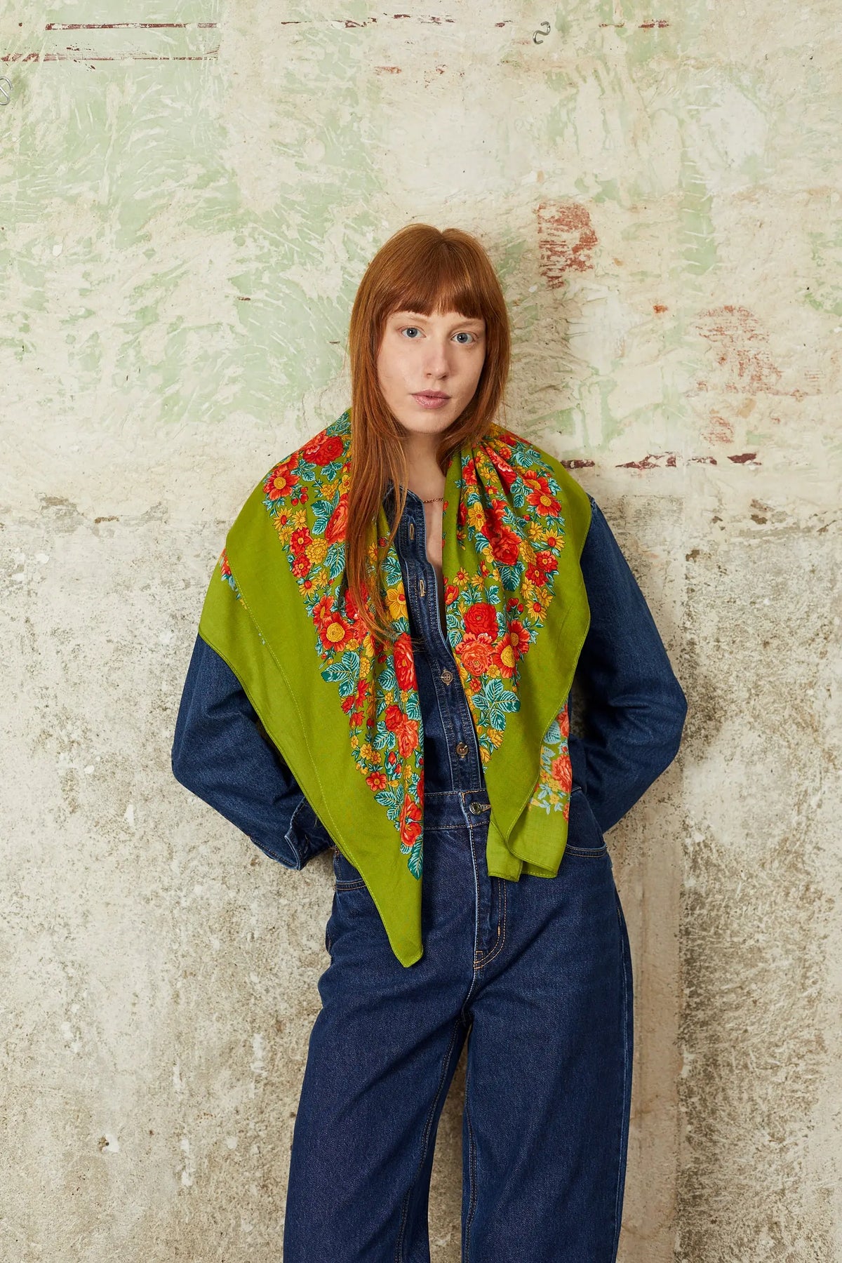 Pañuelo portugués verde oliva con estampado floral multicolor, estilo tradicional sobre mujer con camisa de mezclilla.