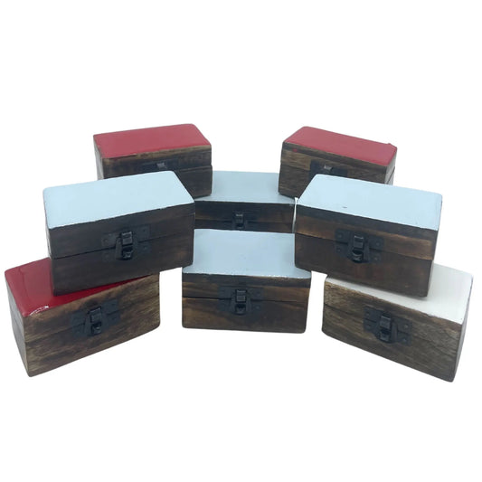 Pastilleros rectangulares de madera con tapas de colores (blanco, rojo, gris) y cierre metálico, sobre fondo blanco.