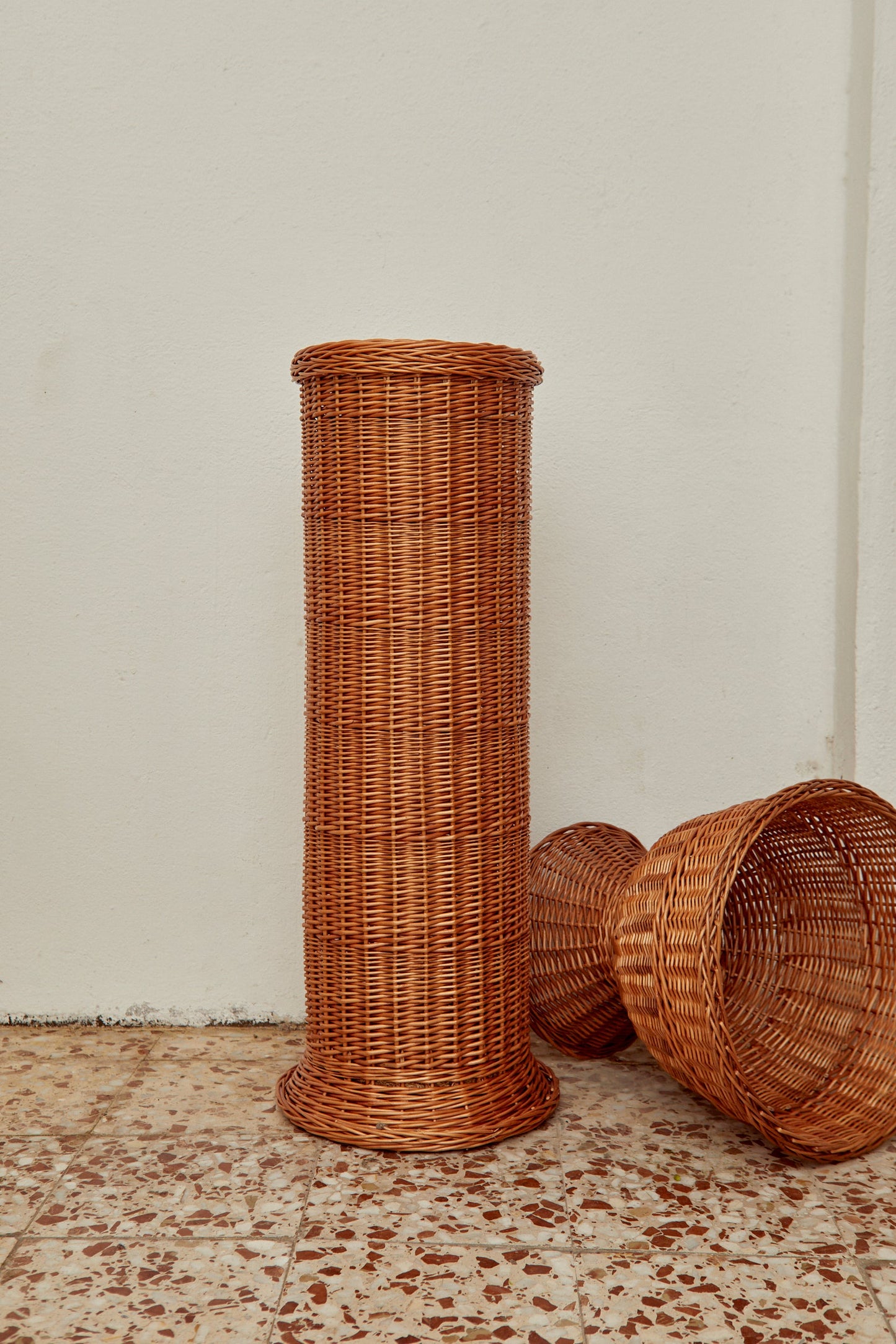Cesta alta de mimbre marrón, estilo contemporáneo, ideal para almacenamiento y decoración moderna.