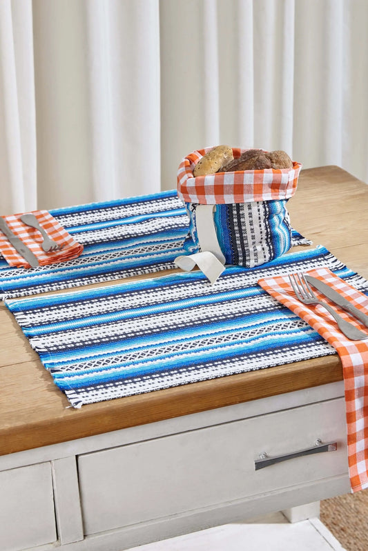 Set of two rectangular blue-toned woven placemats with geometric patterns, displayed on a rustic wooden table.