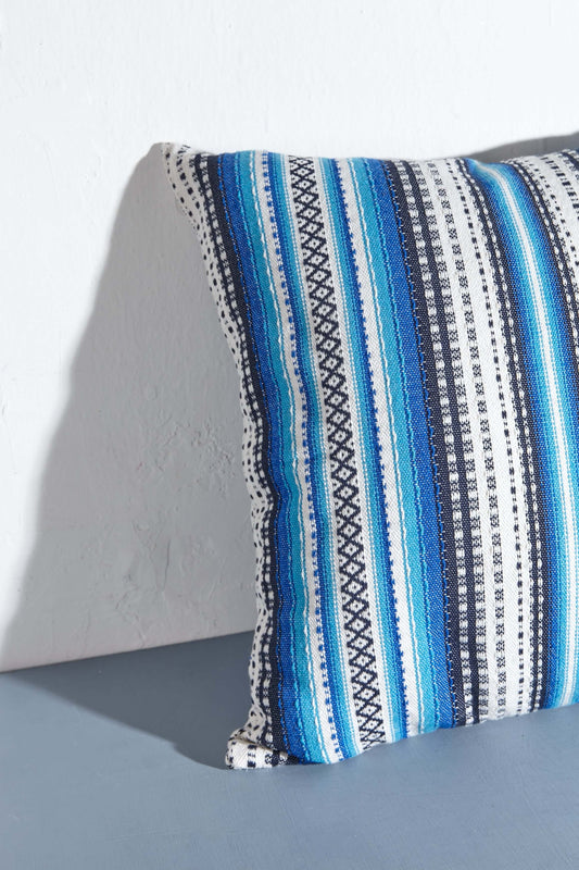 Funda de cojín de 50x50cm con diseño alpujarreño a rayas en tonos azules y blancos, tejido artesanal de textura rústica.