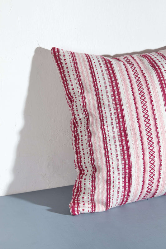 Funda de cojín cuadrada (50x50cm) con diseño de rayas verticales en tonos rosas y texturas artesanales tipo alpujarra.