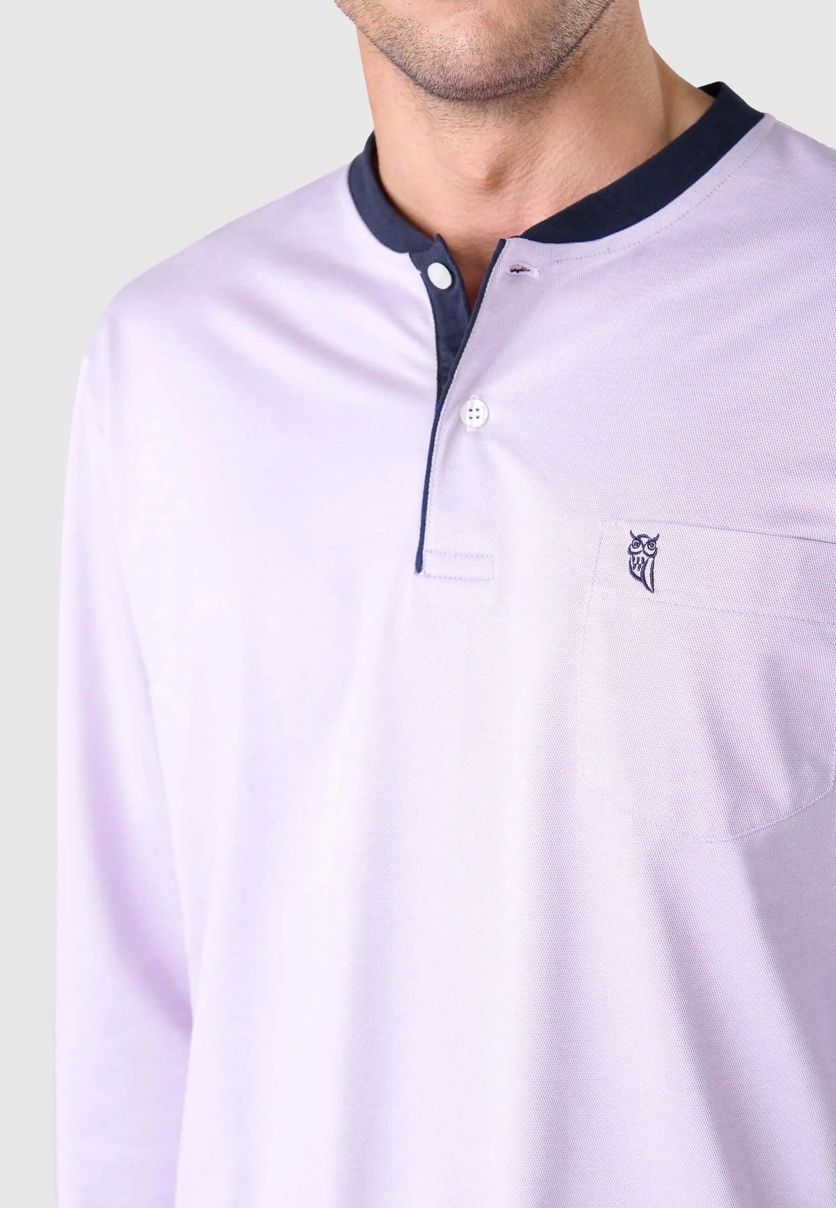 Pijama hombre rosa de piqué con tapeta de botones azul marino, cuello redondo, manga larga y bolsillo con logo bordado.