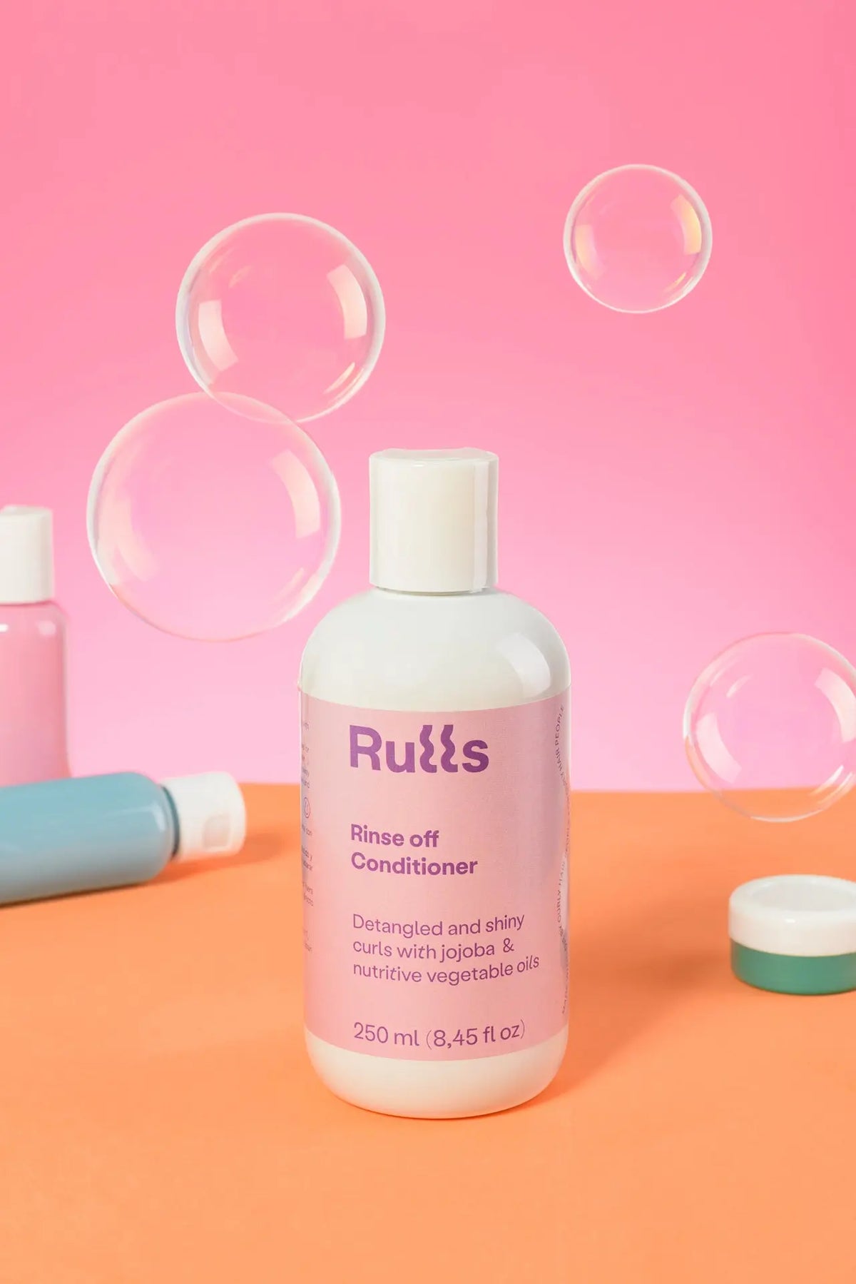 Acondicionador de 250 ml en frasco blanco con etiqueta morada para rizos desenredados y brillantes.