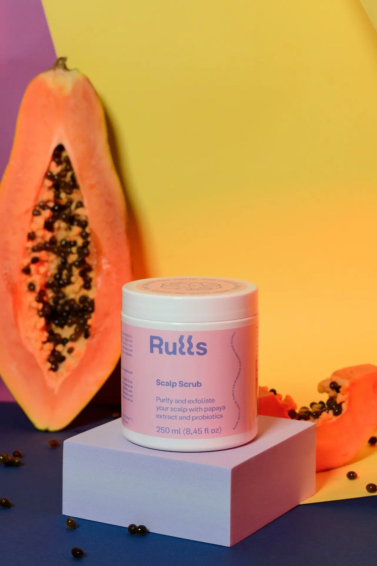 Exfoliante para el cuero cabelludo, 250 ml, con extracto de papaya y probióticos, envase rosa, fondo colorido.
