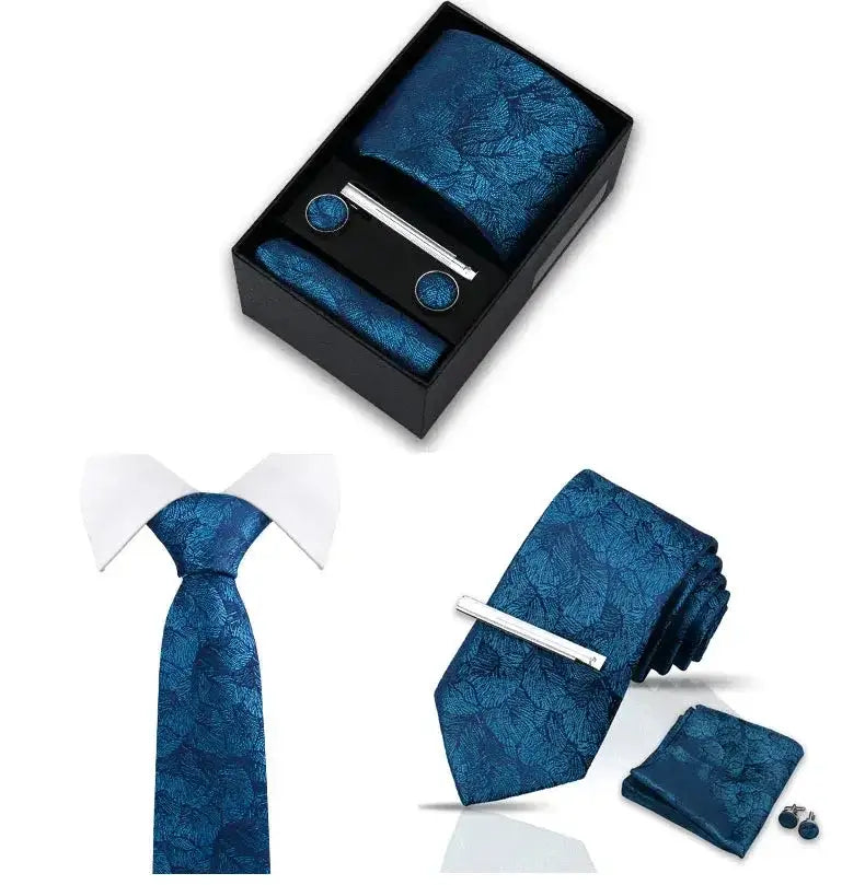 Set de corbata azul con patrón de hojas, pañuelo, gemelos y pasador plateado en caja de regalo. Estilo elegante.