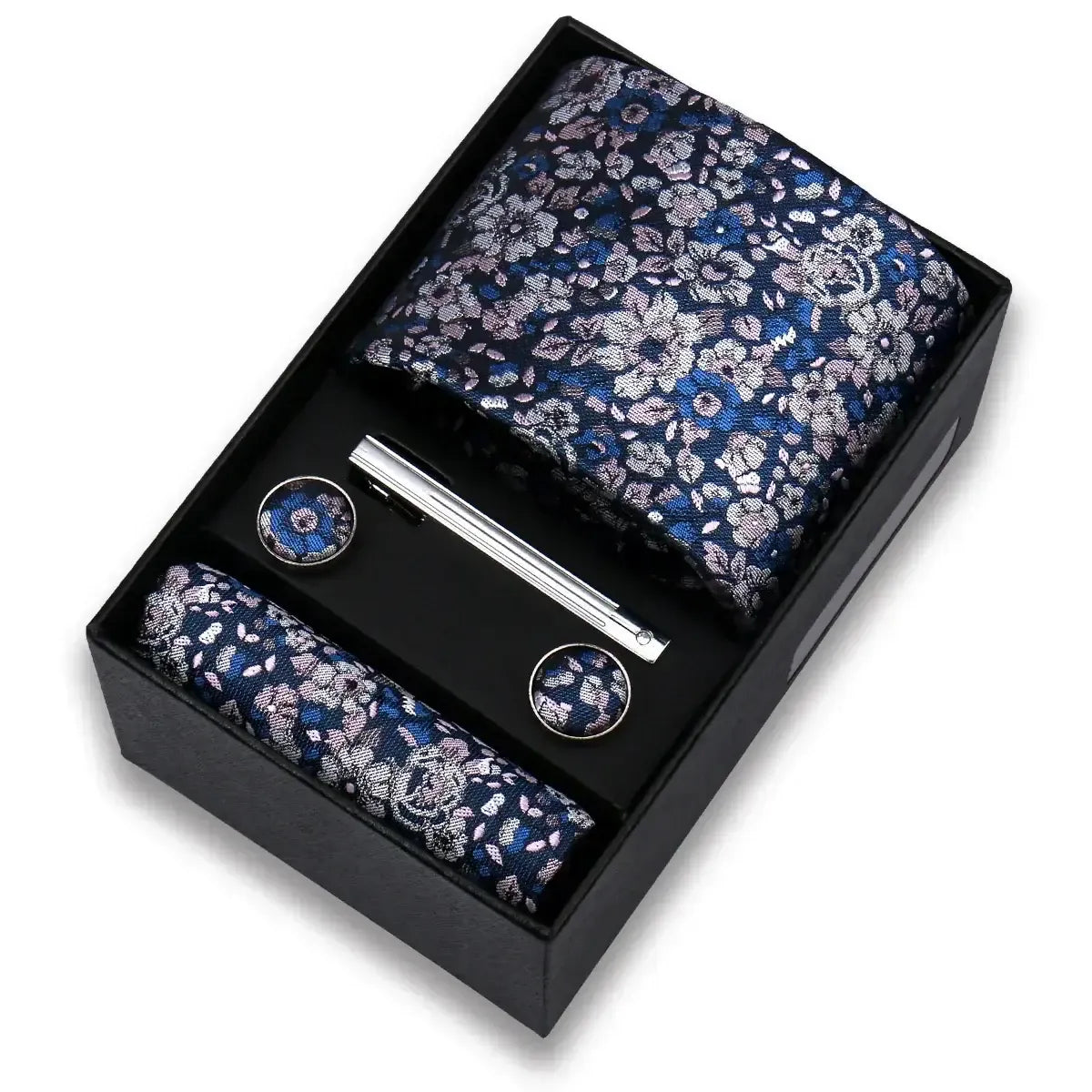 Set de regalo con corbata floral azul y rosa, pañuelo, gemelos y pisacorbata plateado en caja negra elegante.
